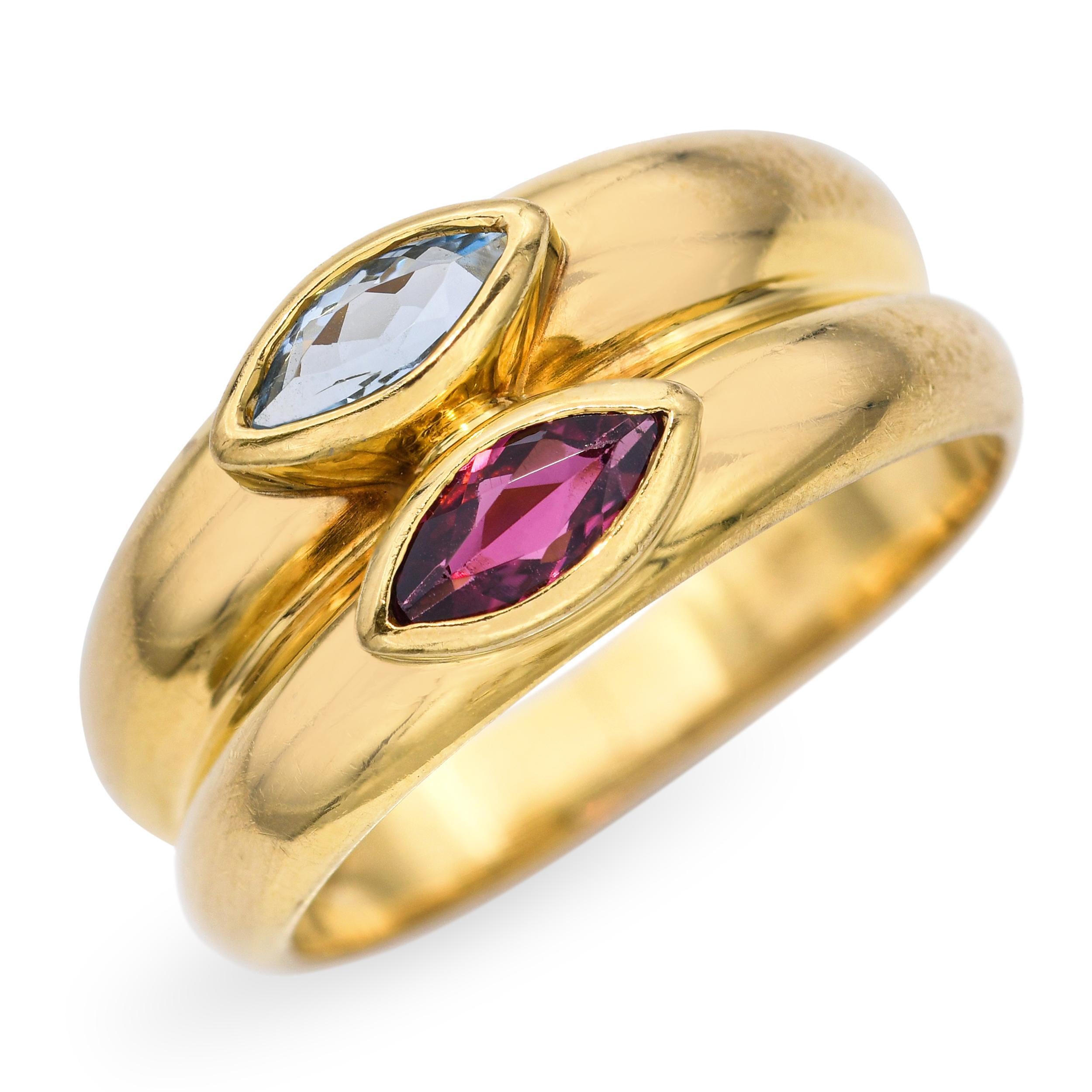 Cette remarquable bague H. Stern présente un double anneau moderne en or jaune 18 carats, offrant une finition riche et rayonnante. Au centre, une aigue-marine aux tons froids et un grenat profond se côtoient, créant un contraste de couleurs