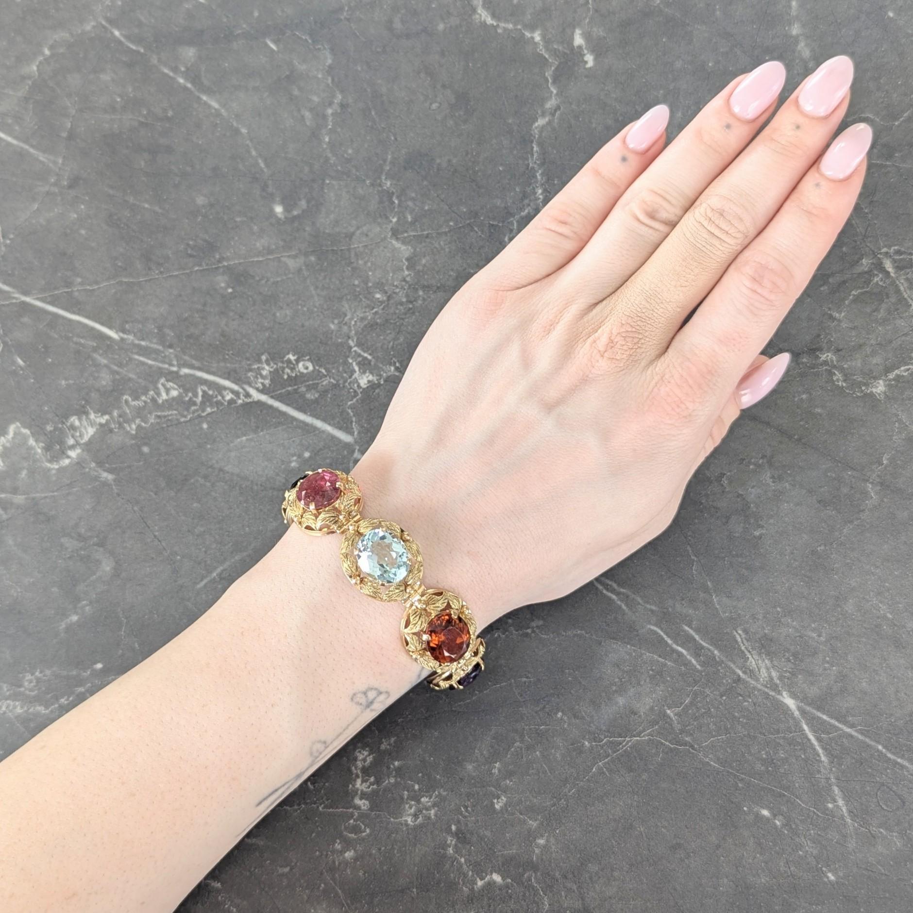 Composé de maillons articulés en or de forme ovale, chacun centré sur une pierre précieuse de taille ovale.
Composé d'améthyste, de citrine, de topaze, de tourmaline et de grenat sertis.
respectivement violet, orange, bleu clair, rose, vert et rouge