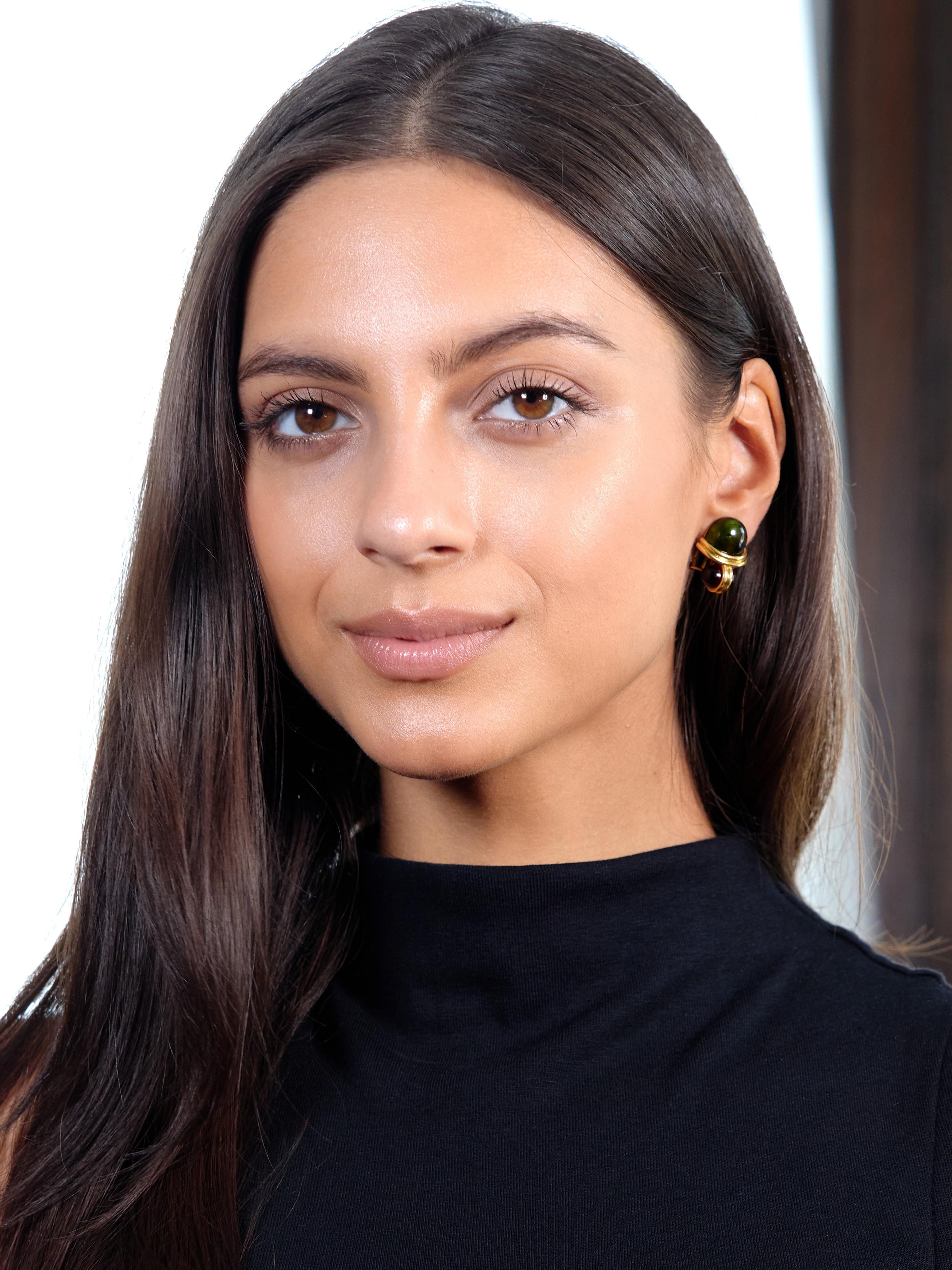 Designed as a geometric pattern comprised of bullet shaped cabochons separated by fluted gold
Featuring tourmaline cabochons measuring 10.0 x 13.0 mm - transparent dark green
Mounted flush against gold backing above mirrored garnet