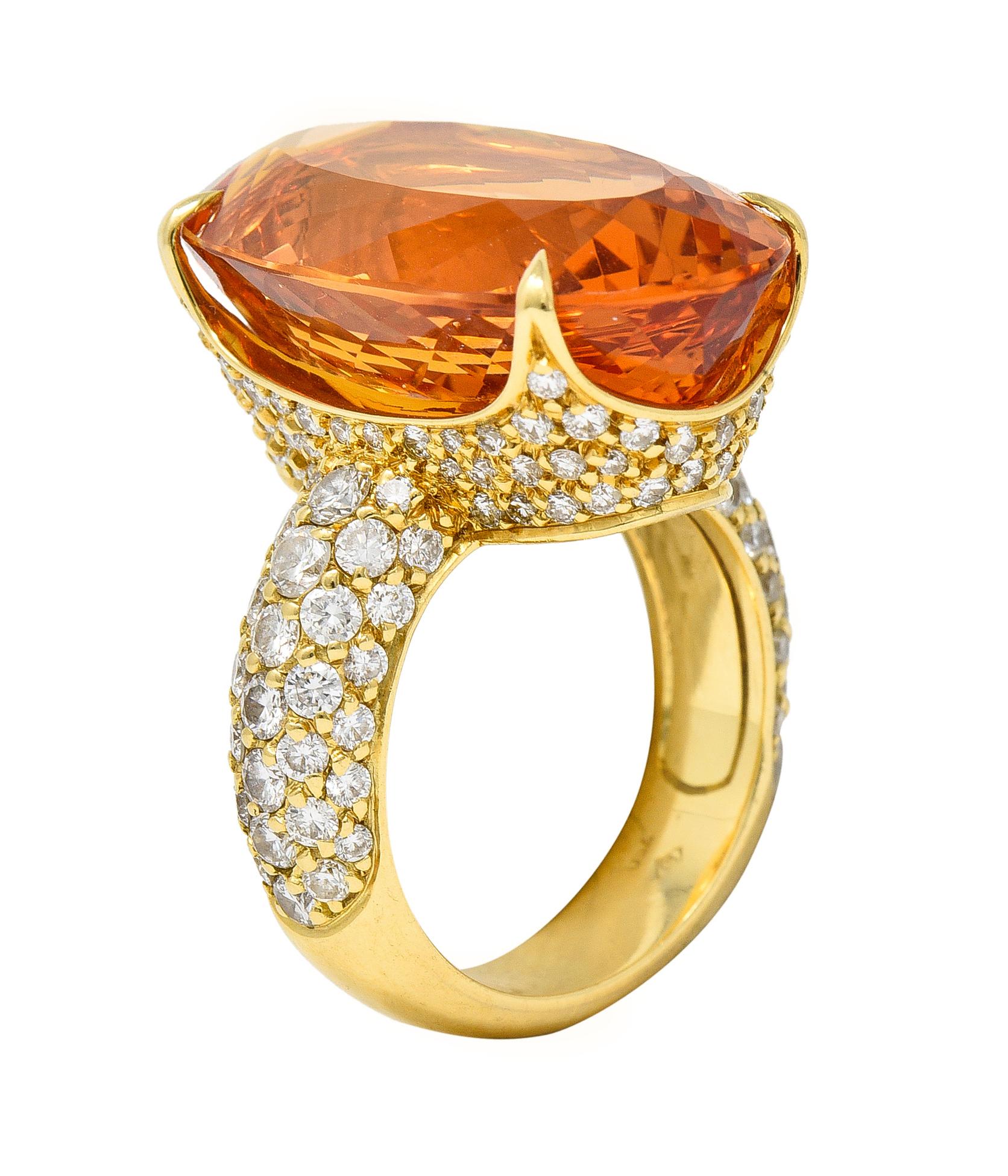 Centering a mixed-cut oval-shaped imperial topaz weighing approximately 24.21 carats
Transparent light to medium pinkish-orange in color and prong set
With round brilliant cut diamonds pavé set in gallery and shoulders
Weighing approximately 1.82