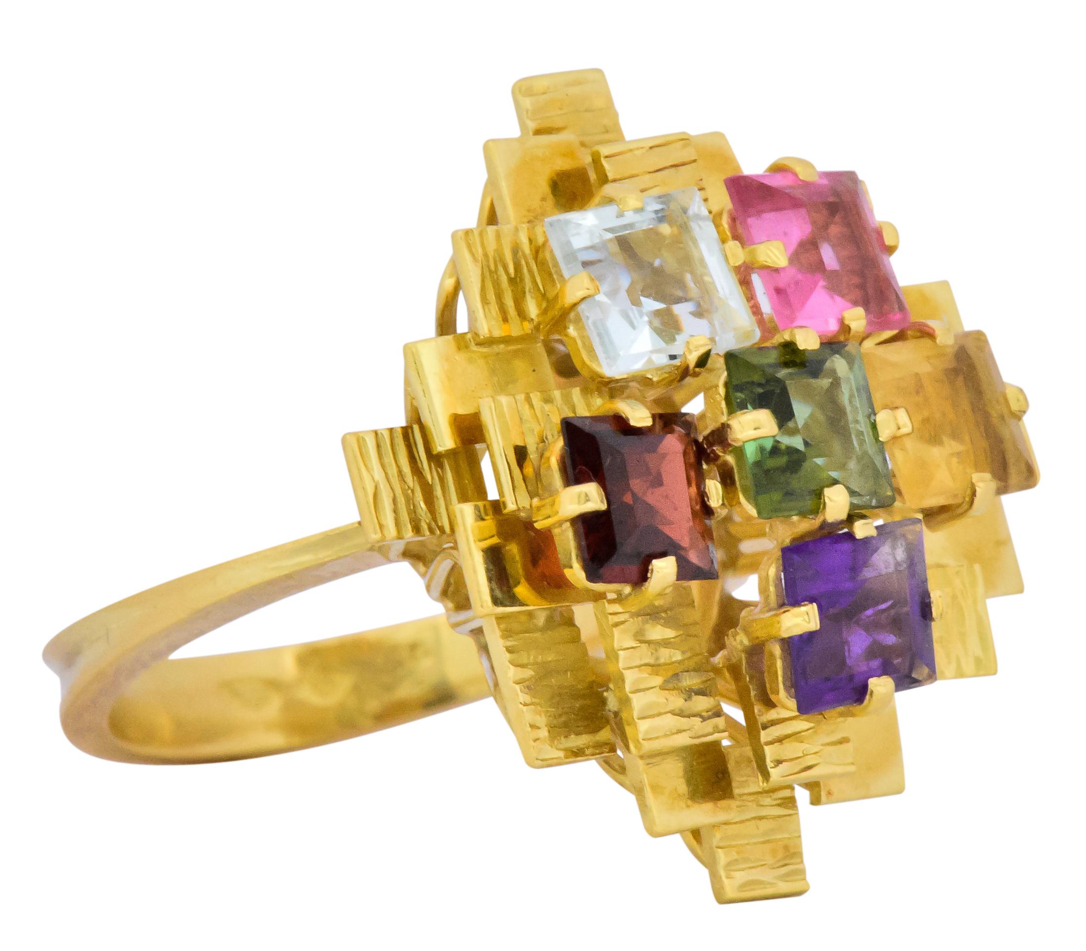 Set with six square step cut gemstones including tourmaline, amethyst, citrine, peridot, aquamarine and garnet, all bright vivid colors

Total gemstone weight approximately 4.35 carats

In a tiered motif with textured and polished gold square