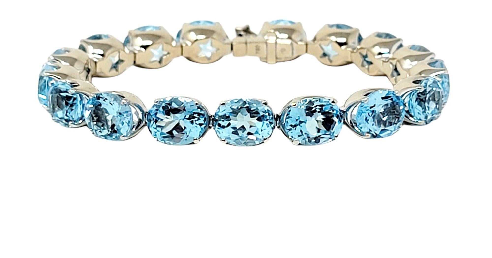 Breathtaking bright blue topaz tennis bracelet by H. Stern. This gorgeous tennis bracelet features an impressive 58.65 carats total of sparkling natural blue topaz stones, bright ice blue in color. The 17 oval cut stones are prong set in a