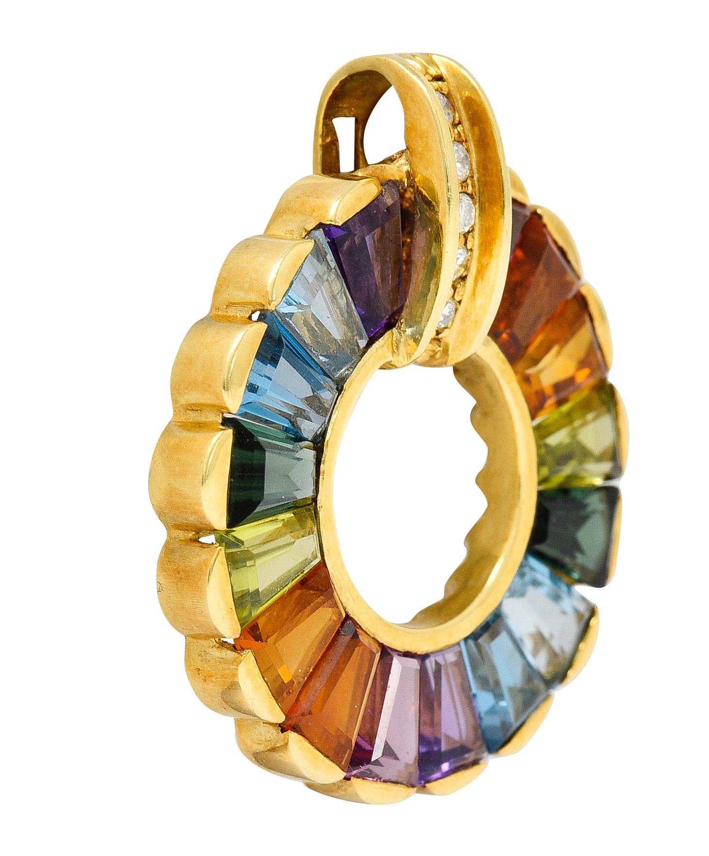 Designed as a circular pendant with a scalloped edge. Comprised of tapered baguette gemstones bar set in a rainbow motif. Featuring blue topaz, citrine, peridot, green & pink tourmaline, and amethyst. Bale is accented by round brilliant cut diamonds