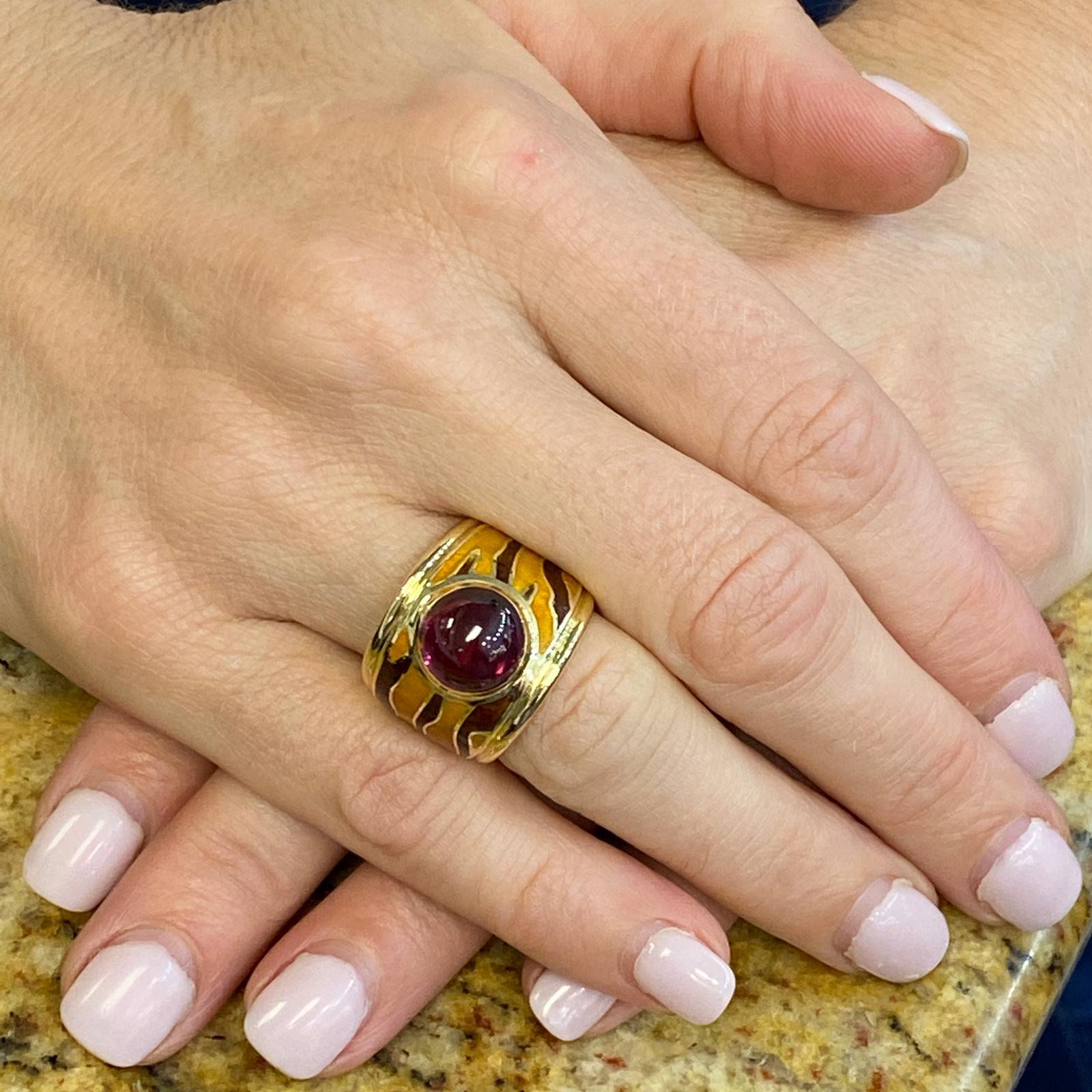 Fabulous enamel rhodolite gemstone ring by designer H. Stern. The wide band features tiger pattern enamel and a bezel set cabochon rhodolite garnet gemstone weighing approximately 4.45 carats. The band measures .75 inches in width and is currently