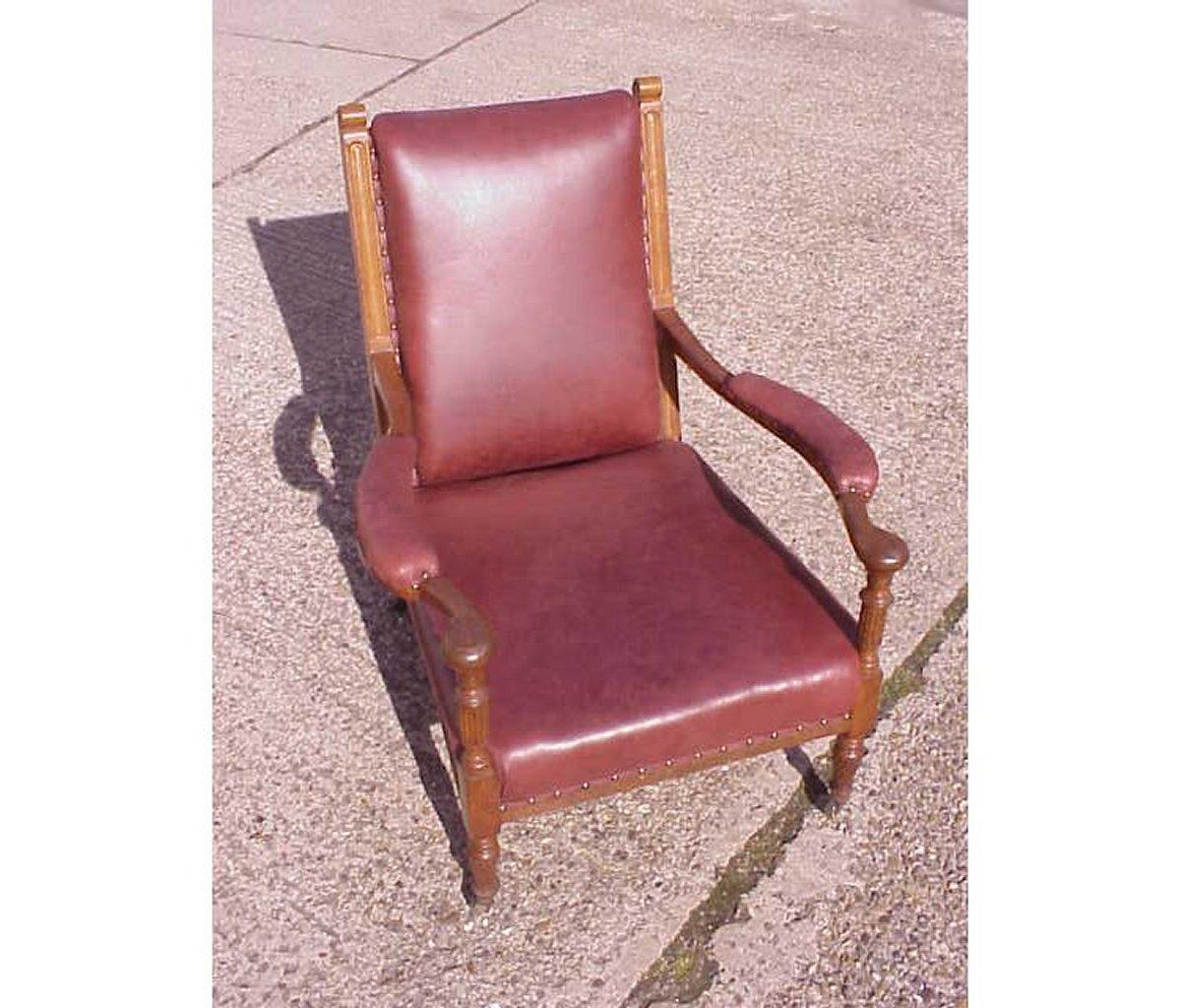 Henry William Batley (zugeschrieben) Jas. Shoolbred, ein Sessel aus Eichenholz, mit rotem Leder bezogen, mit stilisierten floralen Schnitzereien an der Rückenlehne und geschwungenen Armlehnen mit Ellbogenauflagen,  auf kannelierten Stützen und
