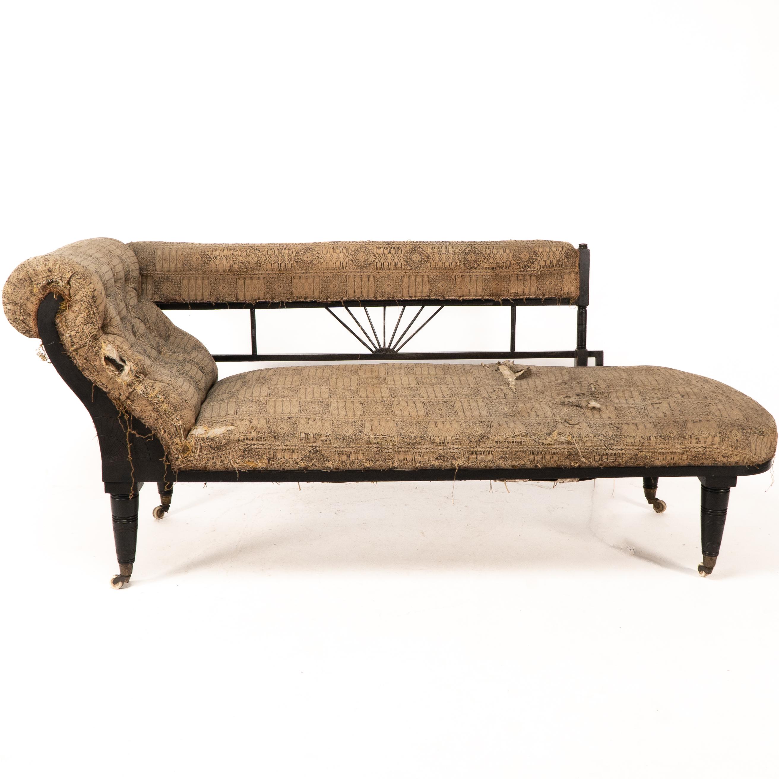 H W Batley zugeschrieben. Eine anglo-japanische ebonisierte Chaiselongue oder ein Tagesbett. Mit einem gepolsterten Arm und sieben fächerförmig eingeschnittenen feinen Drechselarbeiten in der Mitte, flankiert von gedrechselten Pfosten mit einem