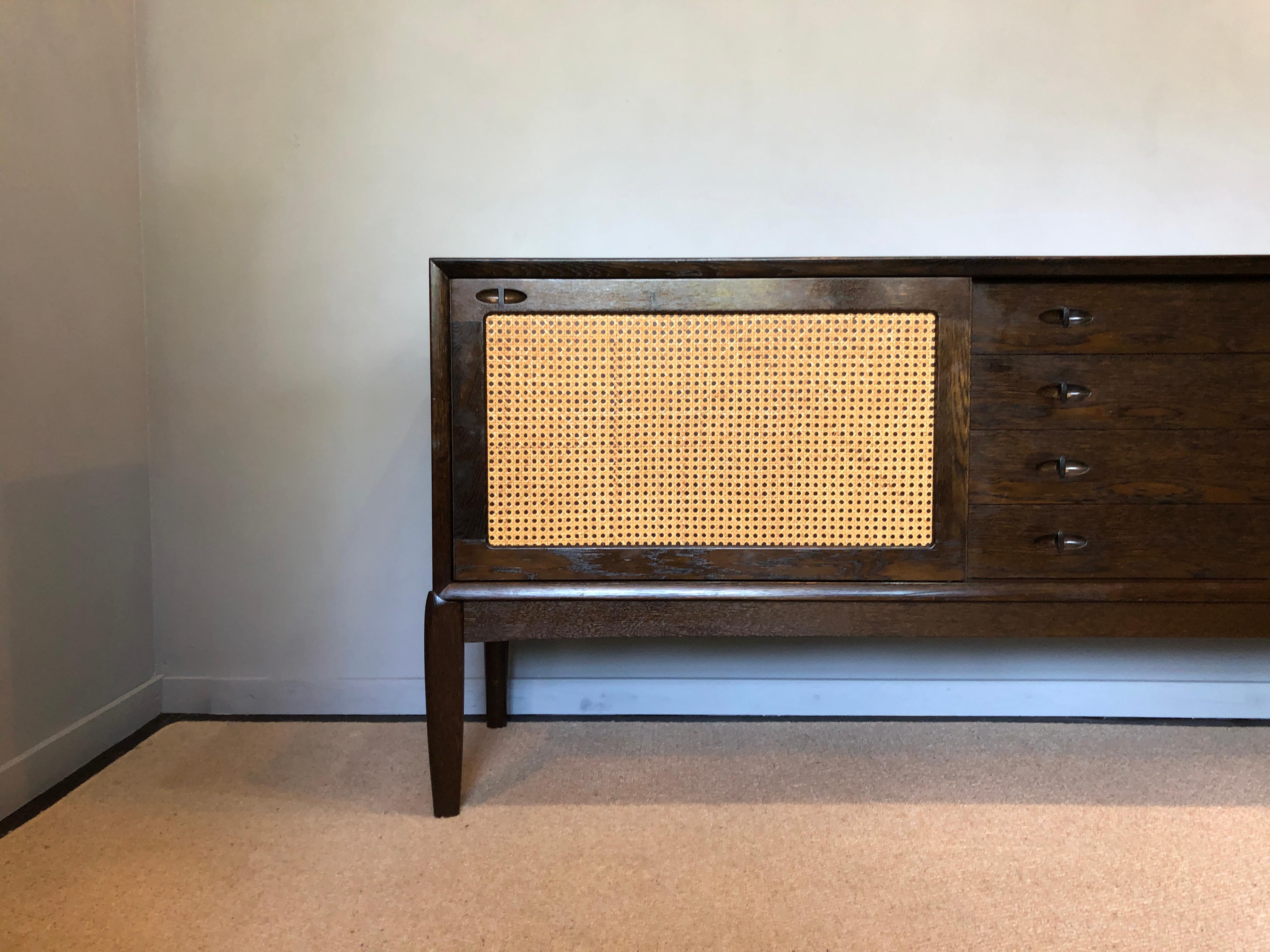 A rare Danish Midcentury Sideboard credenza designed by H. W Klein for Brahmin, Denmark 1960s.
Dark oak with cane fronted panel sliding doors and cut-out finger pulls. Large size: 225 x H80 x D45cm. Internal adjustable shelf each side.
In lovely
