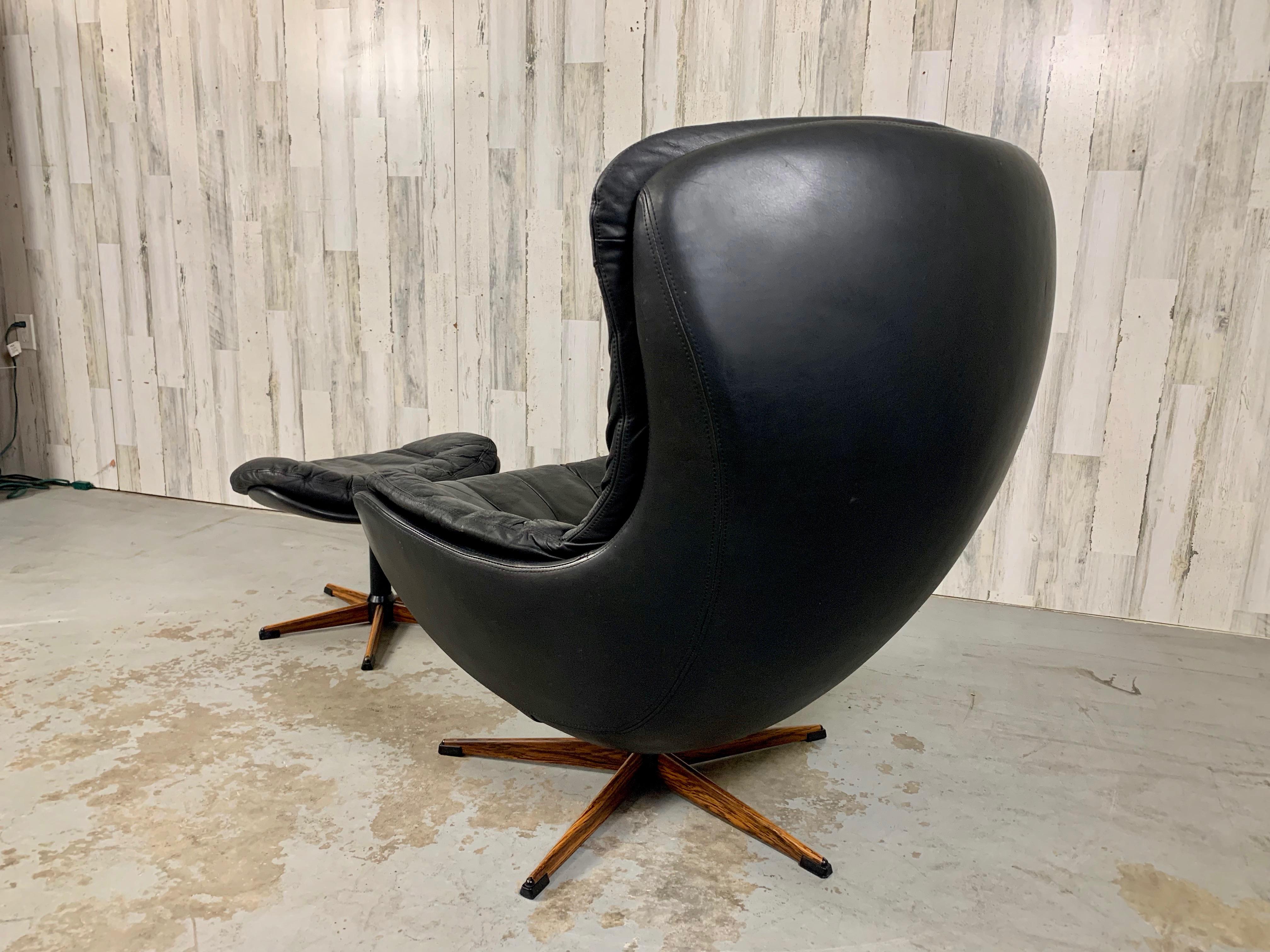 Danish Modern swivel leather lounge chair and ottoman designed by H. W. Klien for Bramin furniture company in Denmark. Nice patina to the leather that you would expect on a piece of this age.
The metal base is covered in rosewood veneer for a