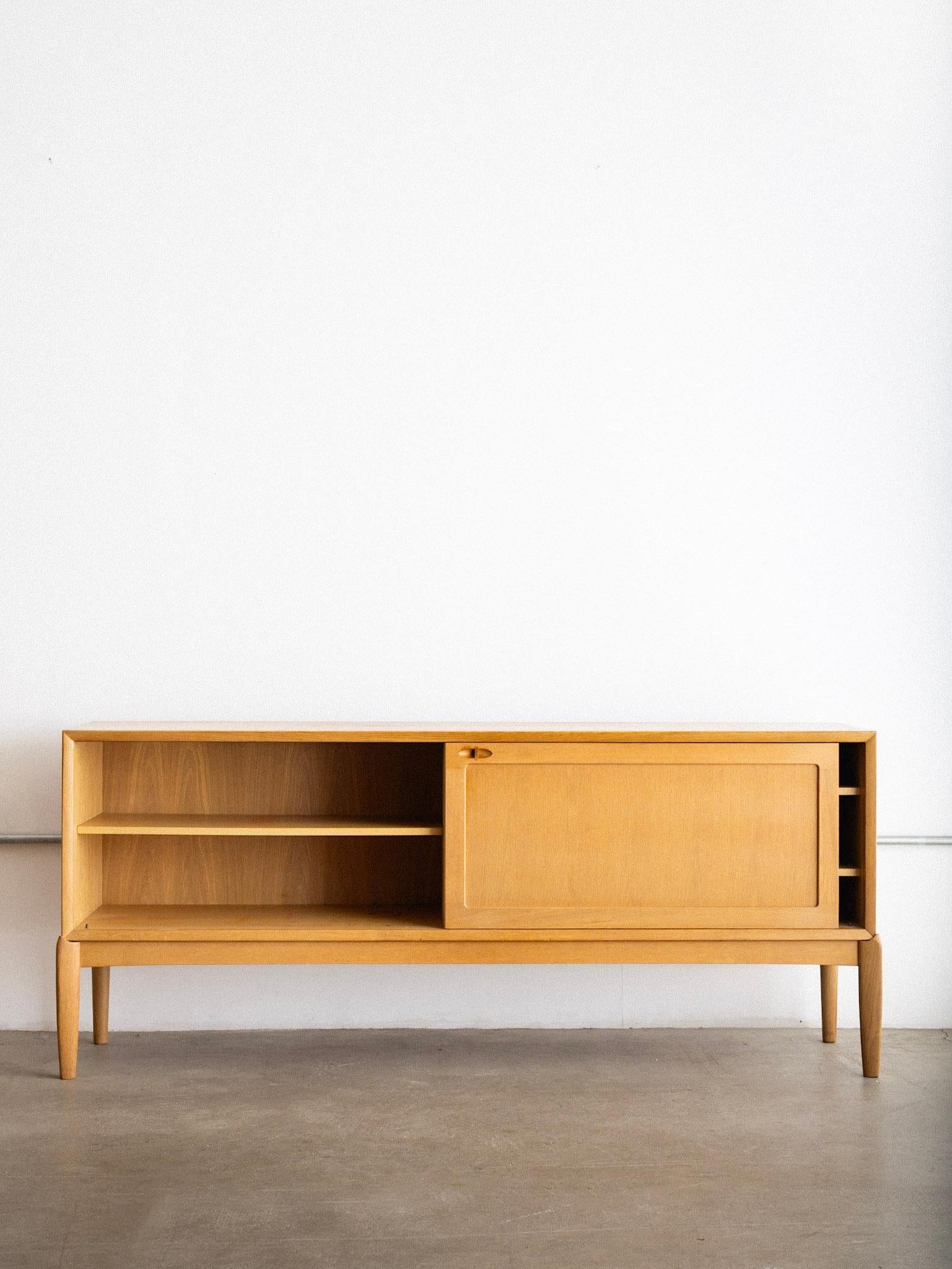 A 1970s H. W. Klein for Bramin oak sideboard. Two sliding doors reveal inner shelving. Blonde oak finish. Marked Bramin, Made in Denmark.

H. W. Klein (Henry Walter Klein, 1919–1992) was a Danish designer known for his refined contributions to