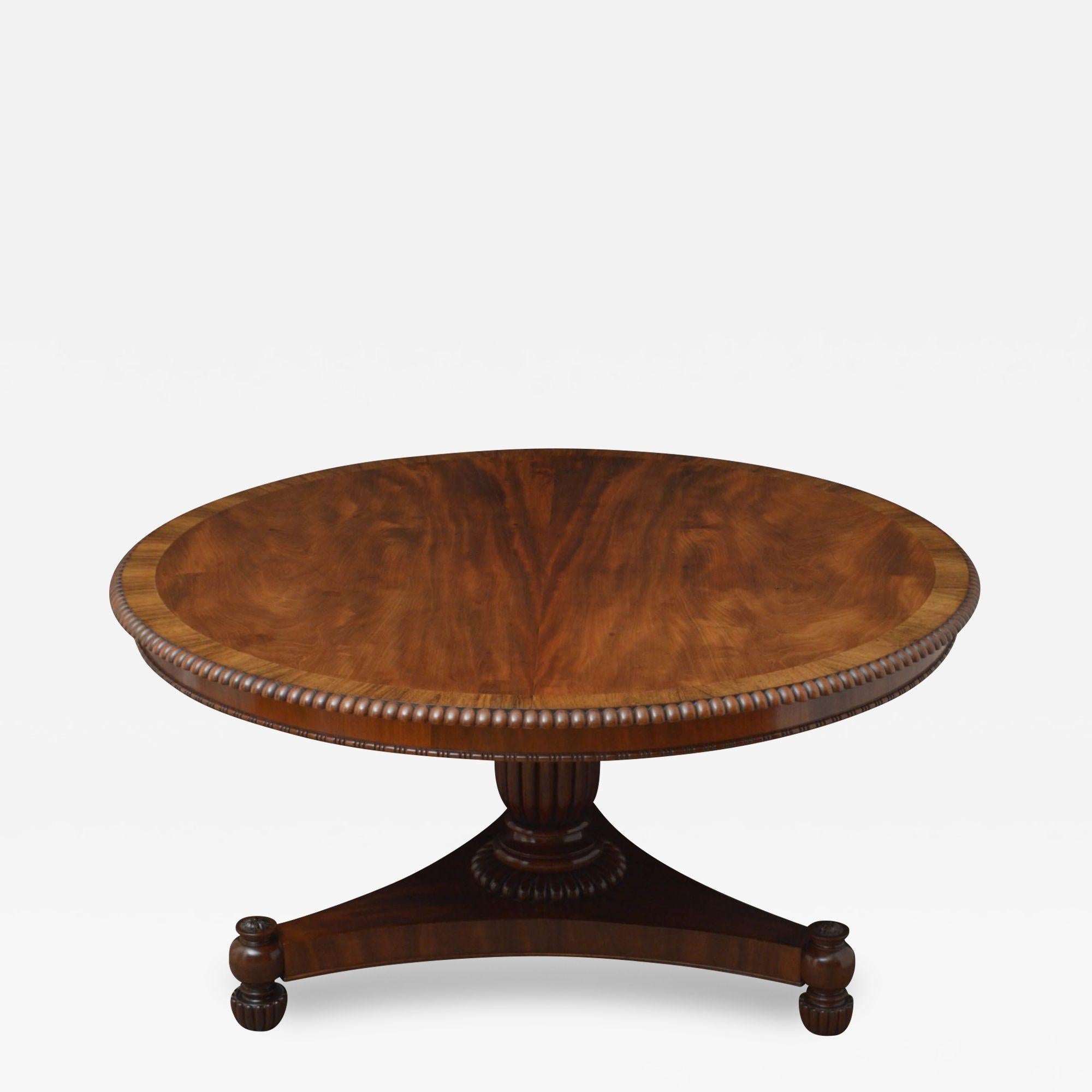 K09 Superb quality Regency, mahogany centre table, having figured mahogany top with rosewood banding and gadroon edge, standing on turned, ringed and fluted column and trefoil base terminating in turned and fluted feet with decorative paterae to the