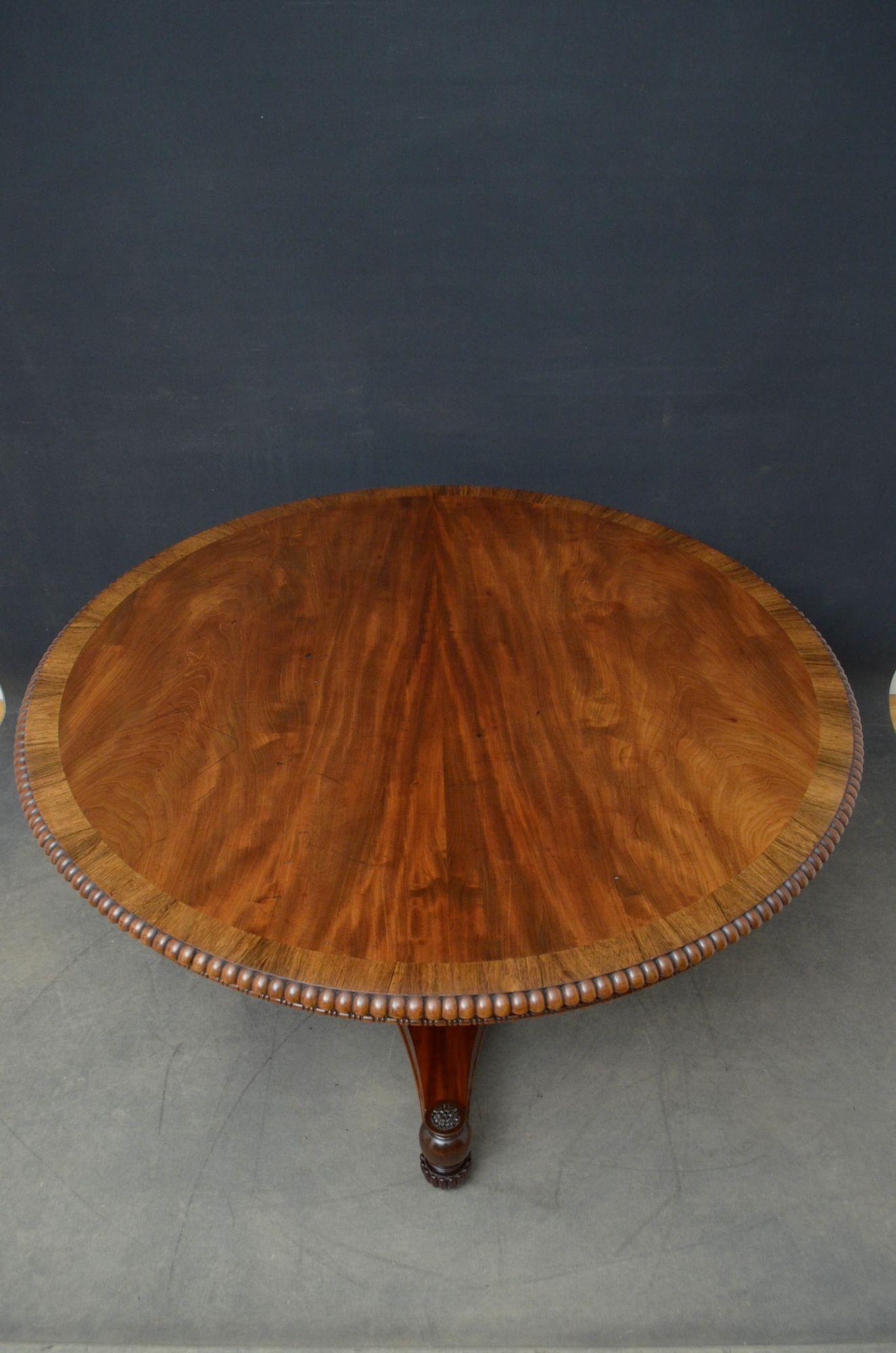 J01 Superbe table centrale en acajou de style Regency, avec un plateau en acajou figuré avec des bandes en bois de rose et des bordures en godrons, reposant sur des colonnes tournées, annelées et cannelées et une base en trèfle se terminant par des