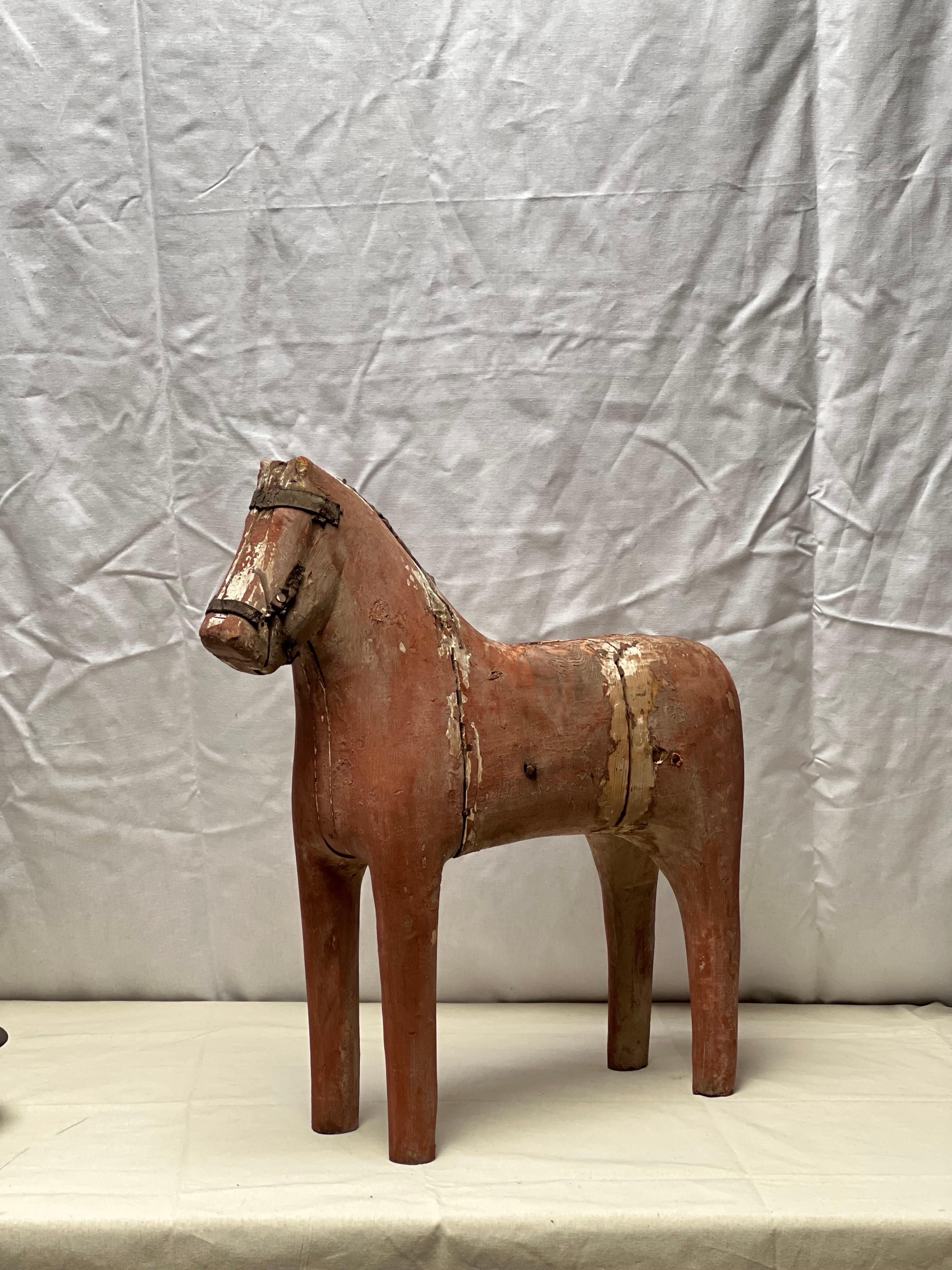 Grand cheval suédois du début du 19e siècle. Fabriqué en bois de pin avec la fameuse peinture rouge. Il est usé mais de façon très agréable. La patine montre la trace du temps. Il y a un trou sur le dessus du dos qui pourrait avoir été utilisé comme