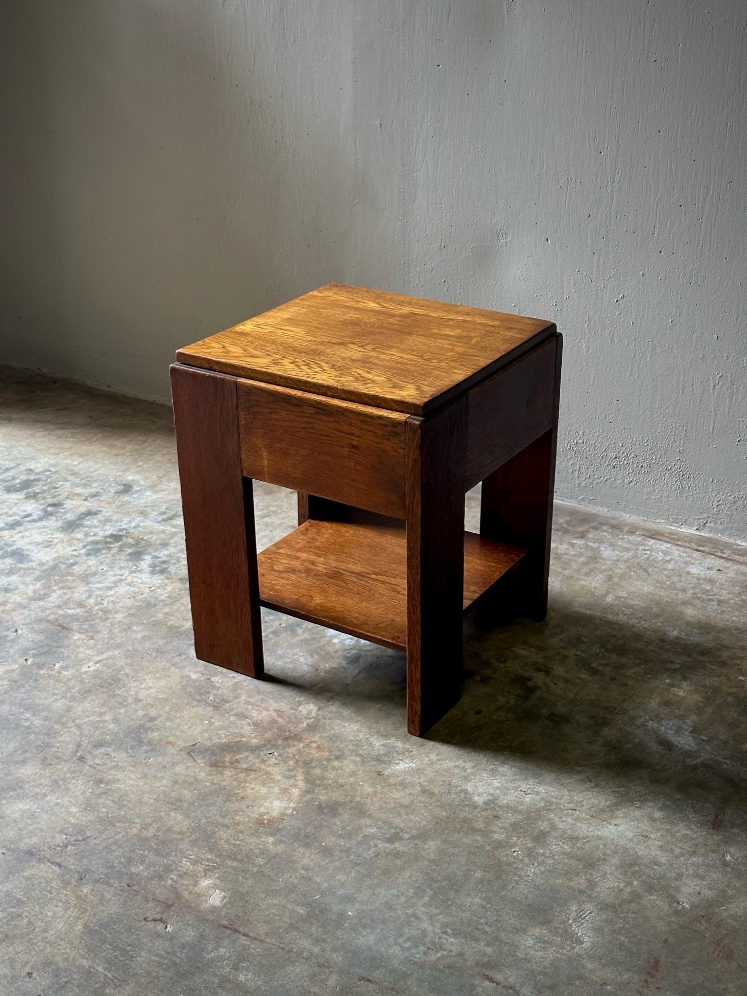 1920s Dutch wood side table with square top, chunky straight legs, and thin lower shelf. A wonderful example of the modernist sensibility the Haagse School was known for, the table emphasizes its materiality with a handsome, minimalist
