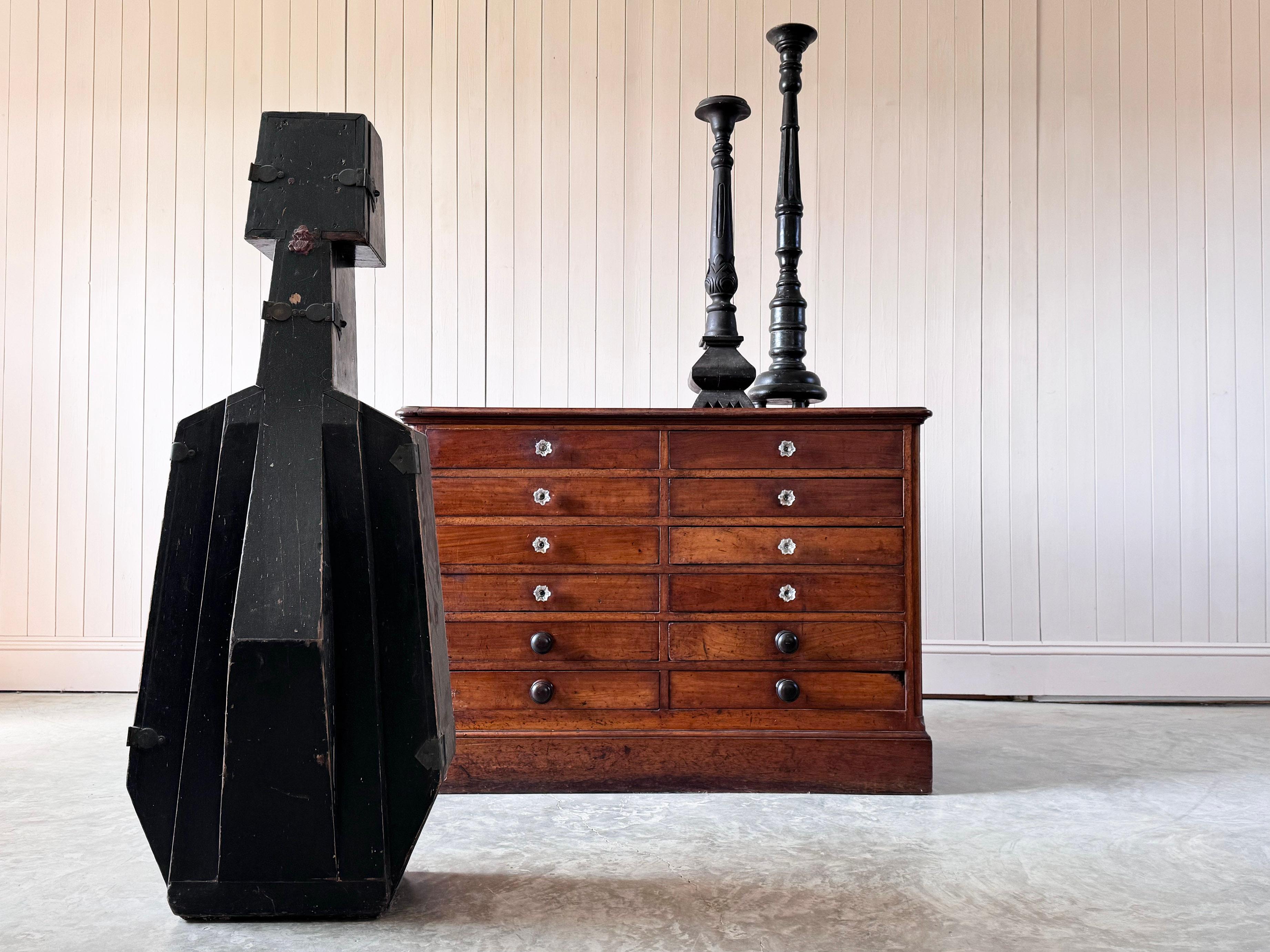 Un eccellente esempio di cassettiera inglese di fine Ottocento in legno di frutto con un'insolita configurazione a dodici cassetti. Questo affascinante cassettone conserva i pomelli in vetro originali dell'epoca vittoriana abbinati a maniglie in