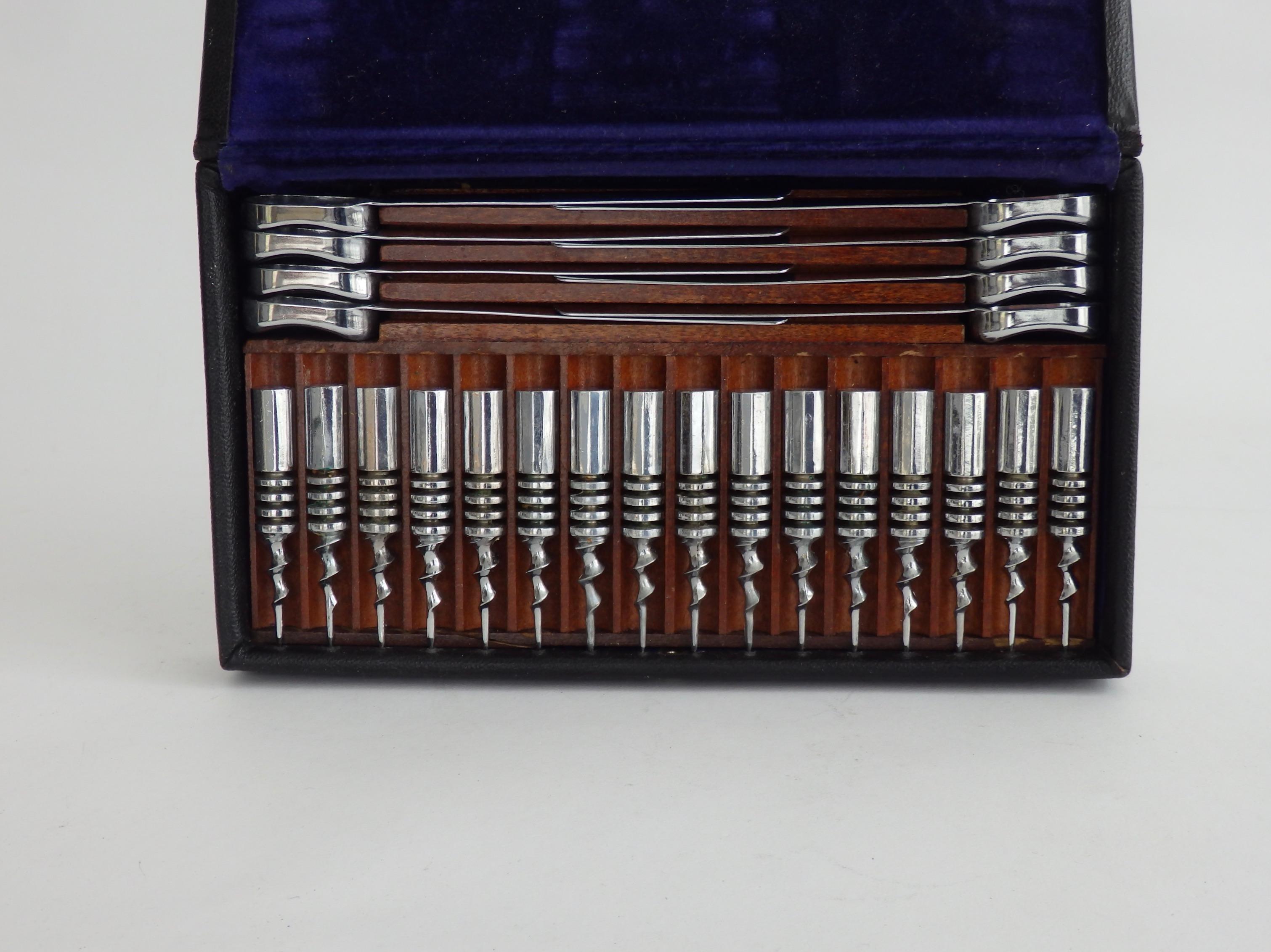 Streamlined Art Deco corn holders and butter pat holders in chrome. 24 pieces in leather covered fitted mahogany box. Made and patented by Hacker co. Excellent condition. Possibly never used.