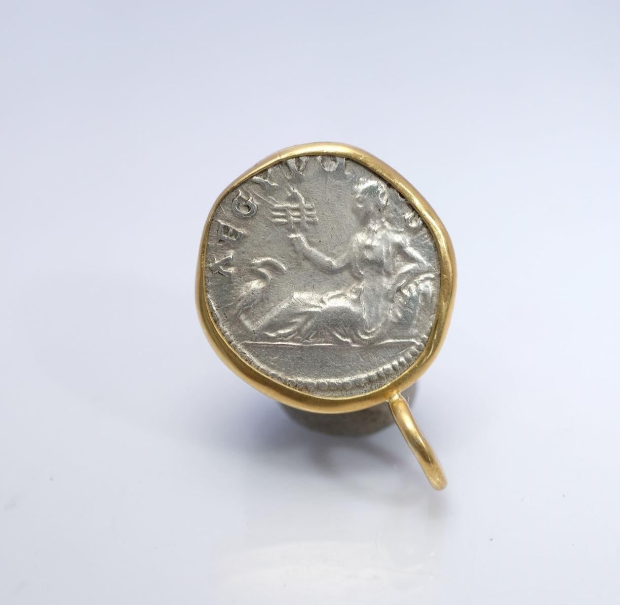 Pour apprécier la taille du pendentif, le relief de la pièce et la forme du fermoir, voir la photo montrant la pièce à côté d'une pièce de 25 cents américains. La pièce a d'abord été enchâssée dans une lunette en or, qui a ensuite été martelée sur