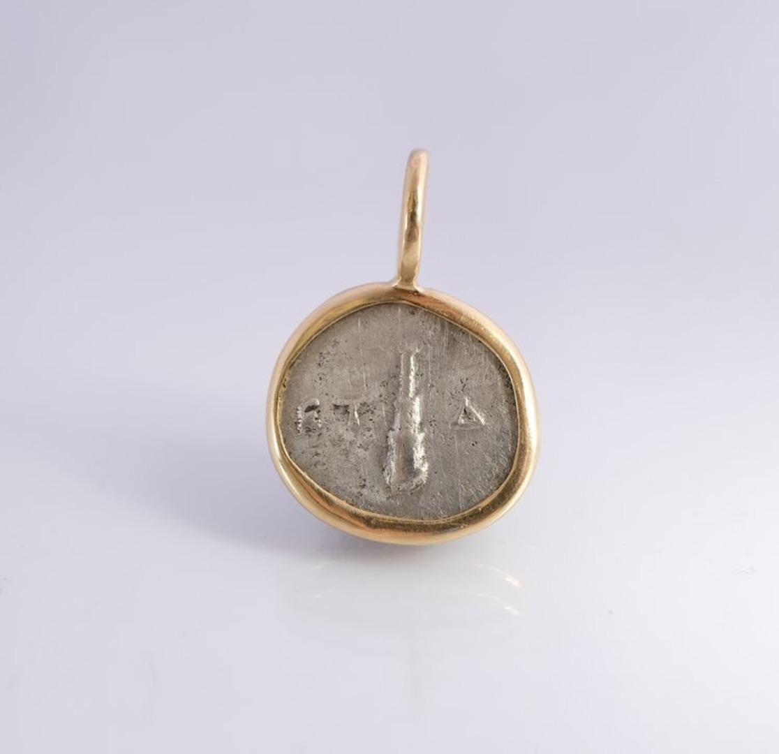 Per apprezzare le dimensioni del ciondolo (13 mm), il rilievo della moneta e la forma della cauzione, guarda la foto che mostra la moneta accanto a un quarto di dollaro americano (che pubblicheremo presto). La moneta è stata prima incastonata in un