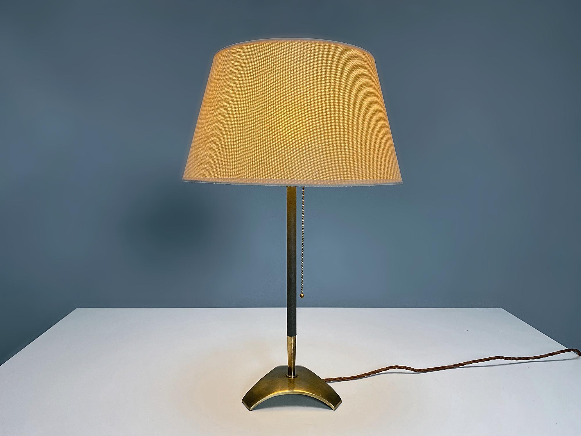 Beautiful Hagenauer Werkstätten brass table lamp manufactured in 1960s, Austria. The lamp is made of polished brass with dark grey-lacquered rod. The lamp provides a smooth and wonderful light. The lamp is in very good original condition, fully