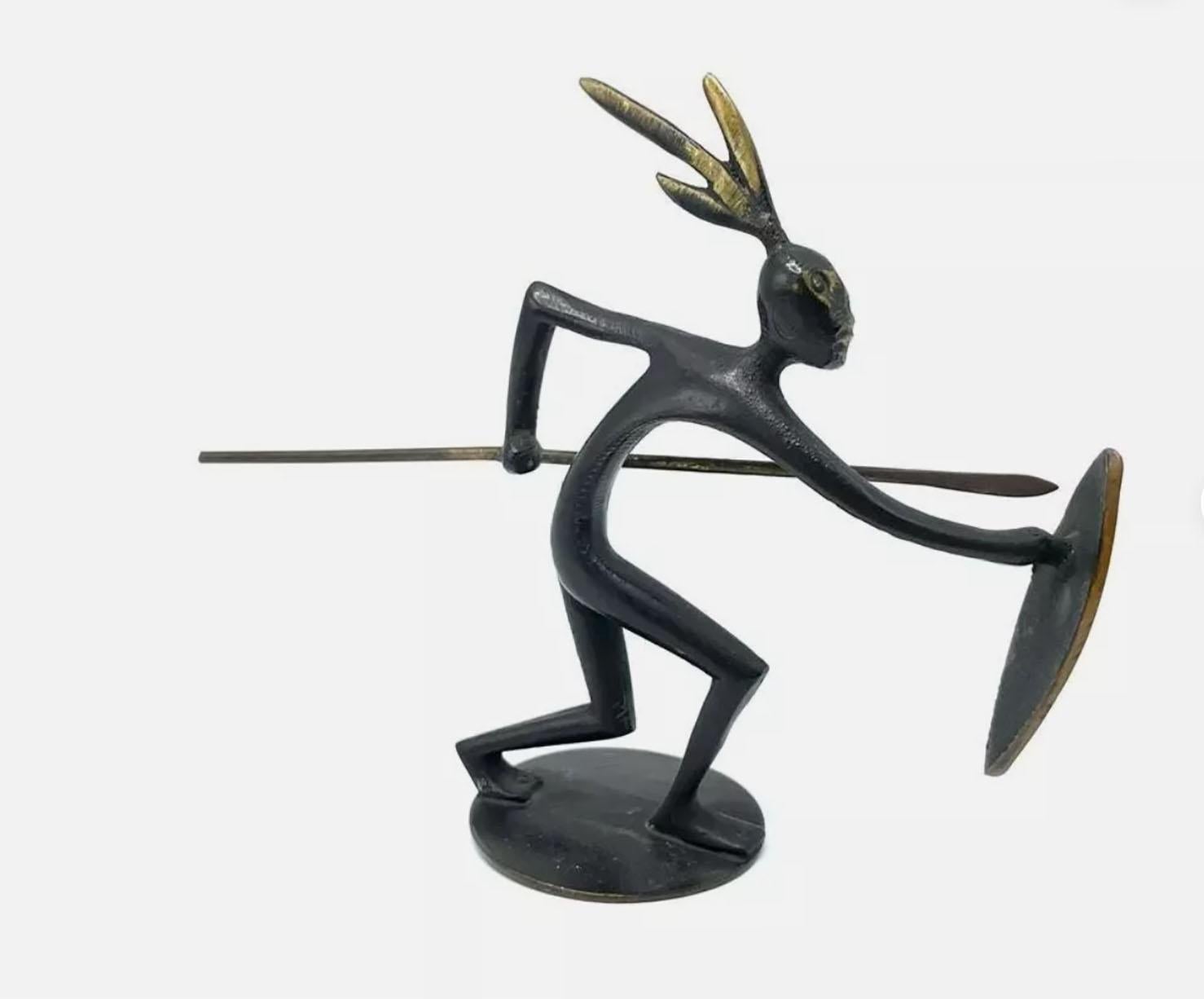 Esta figura de bronce representa a un guerrero estilizado, una pieza característica del estilo Art Déco vienés, atribuida a Karl Hagenauer y producida durante un periodo temprano y poco frecuente de su taller. La escultura se distingue por su diseño