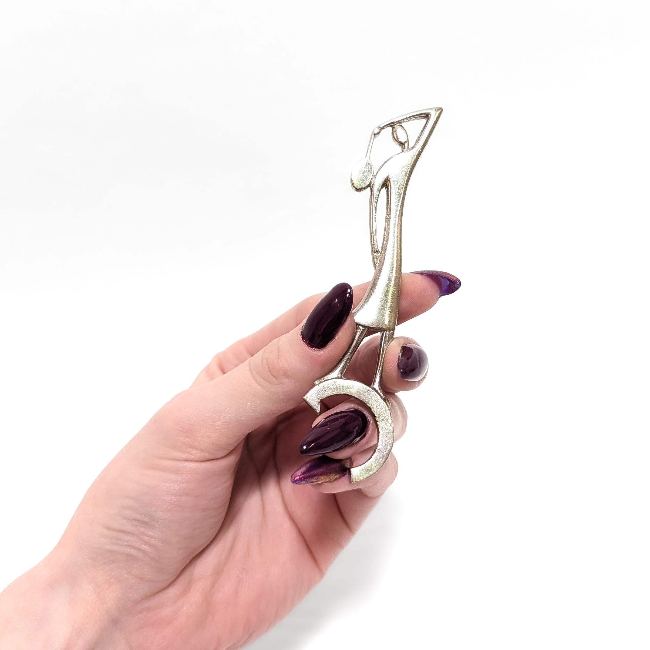 A fine antique Art Deco figural chrome plated bottle opener.

In the Hagenauer style.

In chrome plated brass.

In the form of a figural woman in a dress swinging a tennis racket standing atop a bottle opener.

Apparently unmarked.

Simply wonderful