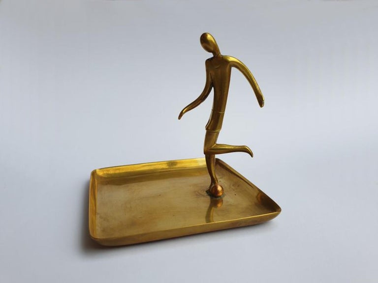 Art Deco ca. 1925. Soccer player figure mounted on square bowl. Brass. Designed and made by Hagenauer Werkstätte, Vienna. Marked on the underside WHW in a circle and Made in Austria
Measurements: Height: 3.15 in (8 cm), Width: 3.15 in (8 cm), Depth:
