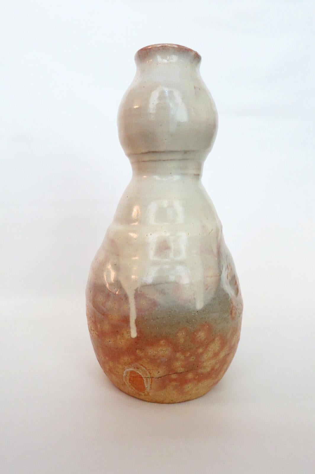 A stoneware vase with white dripping glaze from Hagi by Kyusetsu Miwa X (1895-1981), Showa Period. The vase is in the shape of 