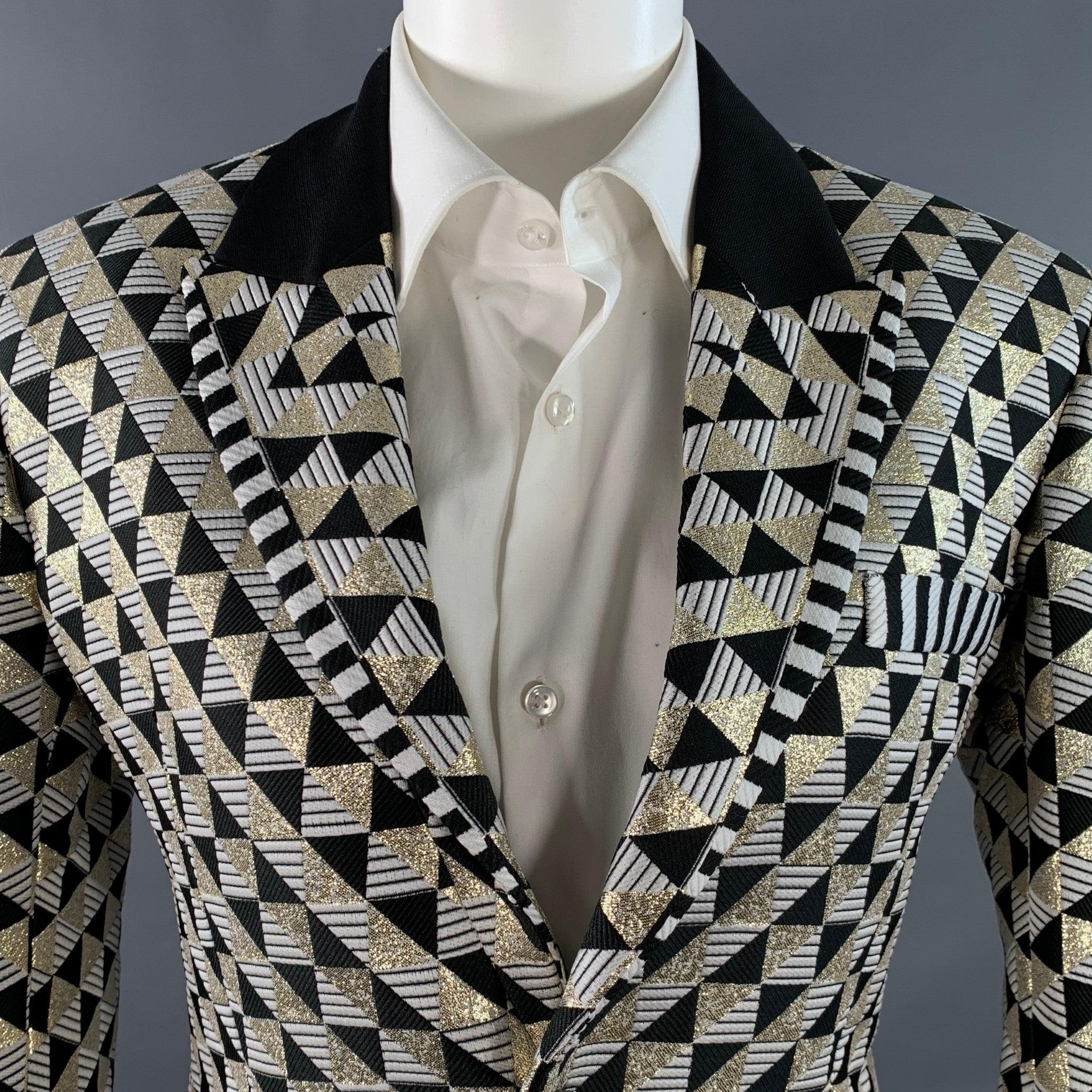 HAIDER ACKERMANN tuxedo sport coat
in a black, white, and metallic gold tone polyester blend featuring a geometric pattern, contrasting grosgrain peak lapel, double vented back, and single button closure. New with Tags. 

Marked:   IT 44