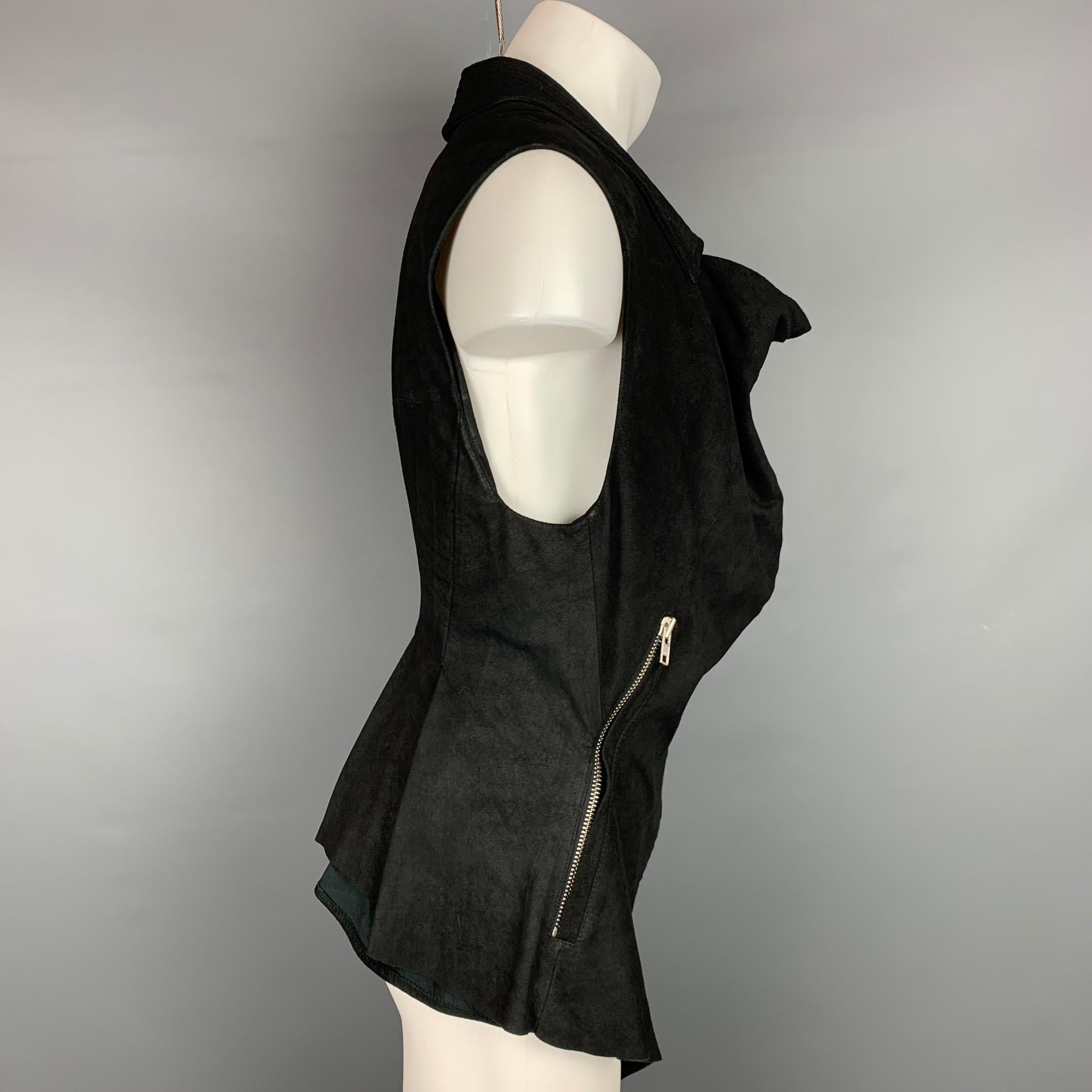 El chaleco HAIDER ACKERMANN se presenta en ante negro sin forro, con herrajes en tono plateado, cuello abierto, bolsillos con cremallera y cierre completo con cremallera. Fabricado en Italia.

Muy buen estado de conservación.
Marcado: 38
Precio de