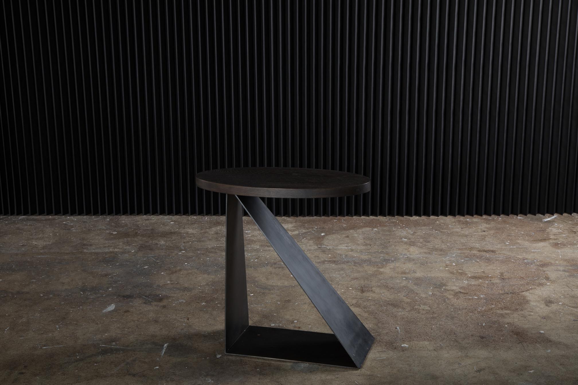 Form and function. The Haider side table takes cues from Haider Ackerman's designs—sharp edges made possible by darts and unexpected seaming, an edginess that is emulated in the base of this piece. Harsh lines and clean edges offer a beautiful