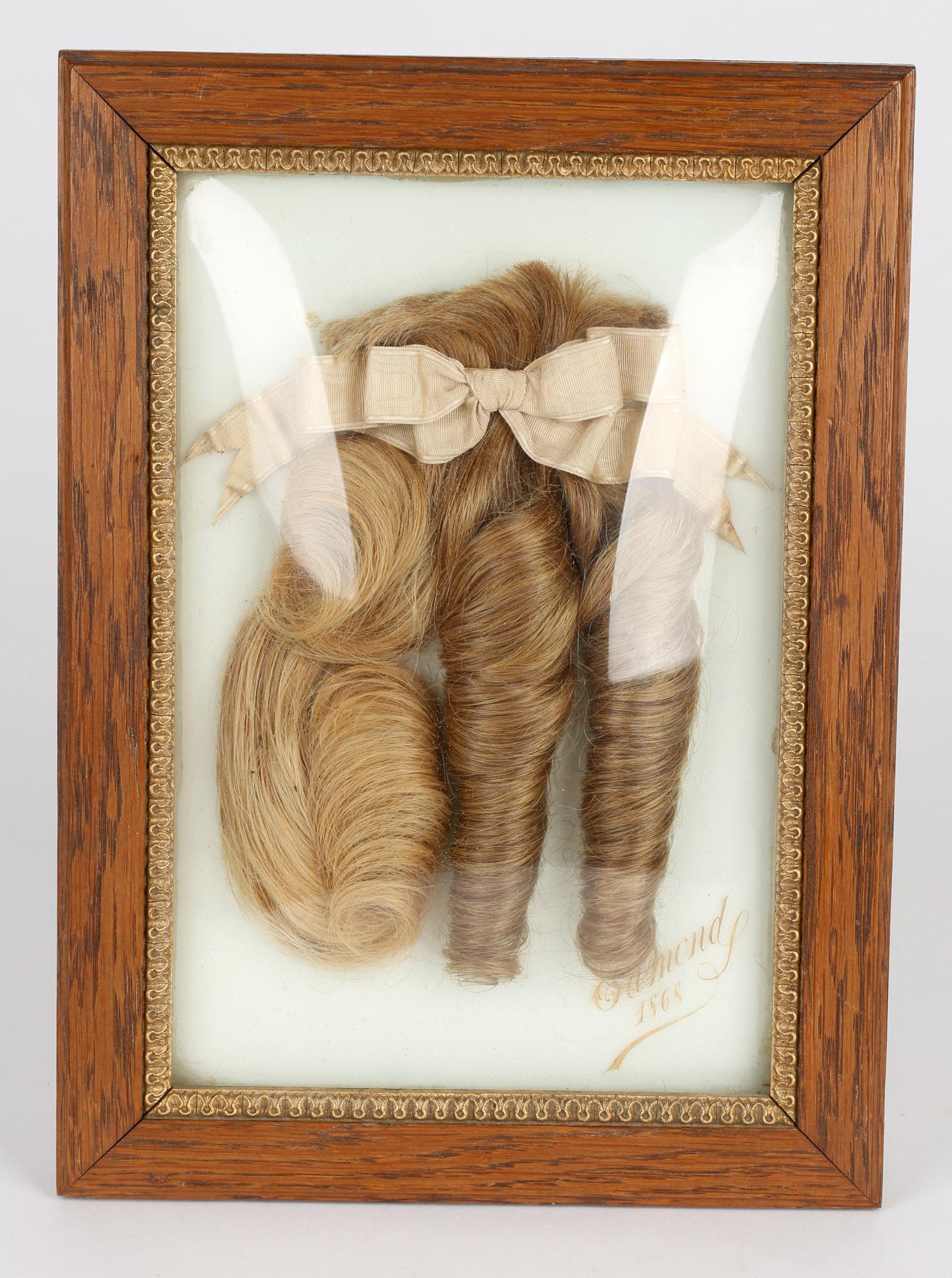 Unusual and rare French Parisian hairdressers advertising framed hair display marked Edmonds and dated 1868. Of hairdresser interest the hand crafted oak frame has a bow glass front and displays three locks of hair tied with a silk ribbon and set