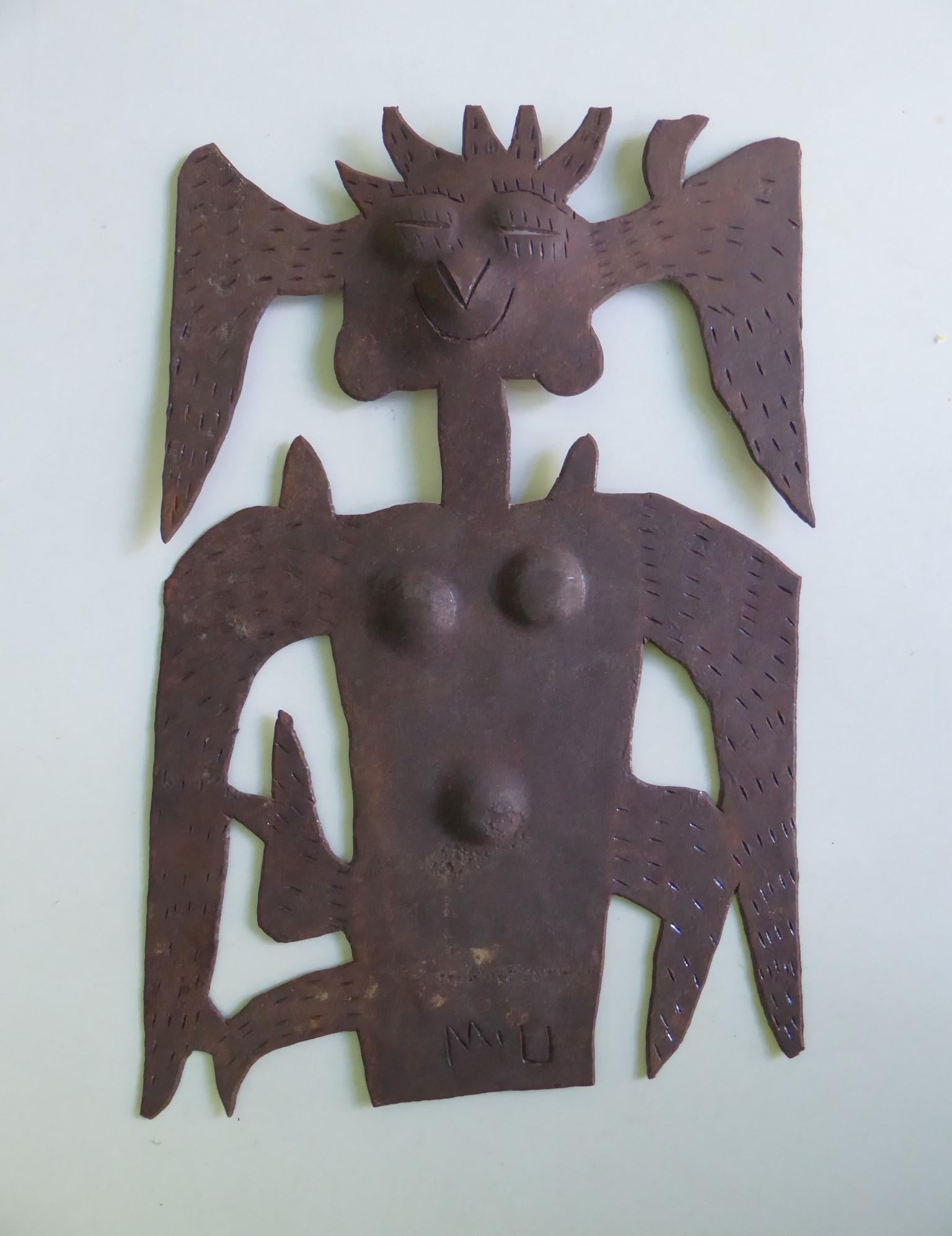 Haitian metal art wall decoration from the 1970s signed M.U. The design is of a figure in festive regalia.  The eyes, noses and partially the mouth are cut all the way .

A unique Haitian form of the art of steel drum sculpture.   Primarily produced