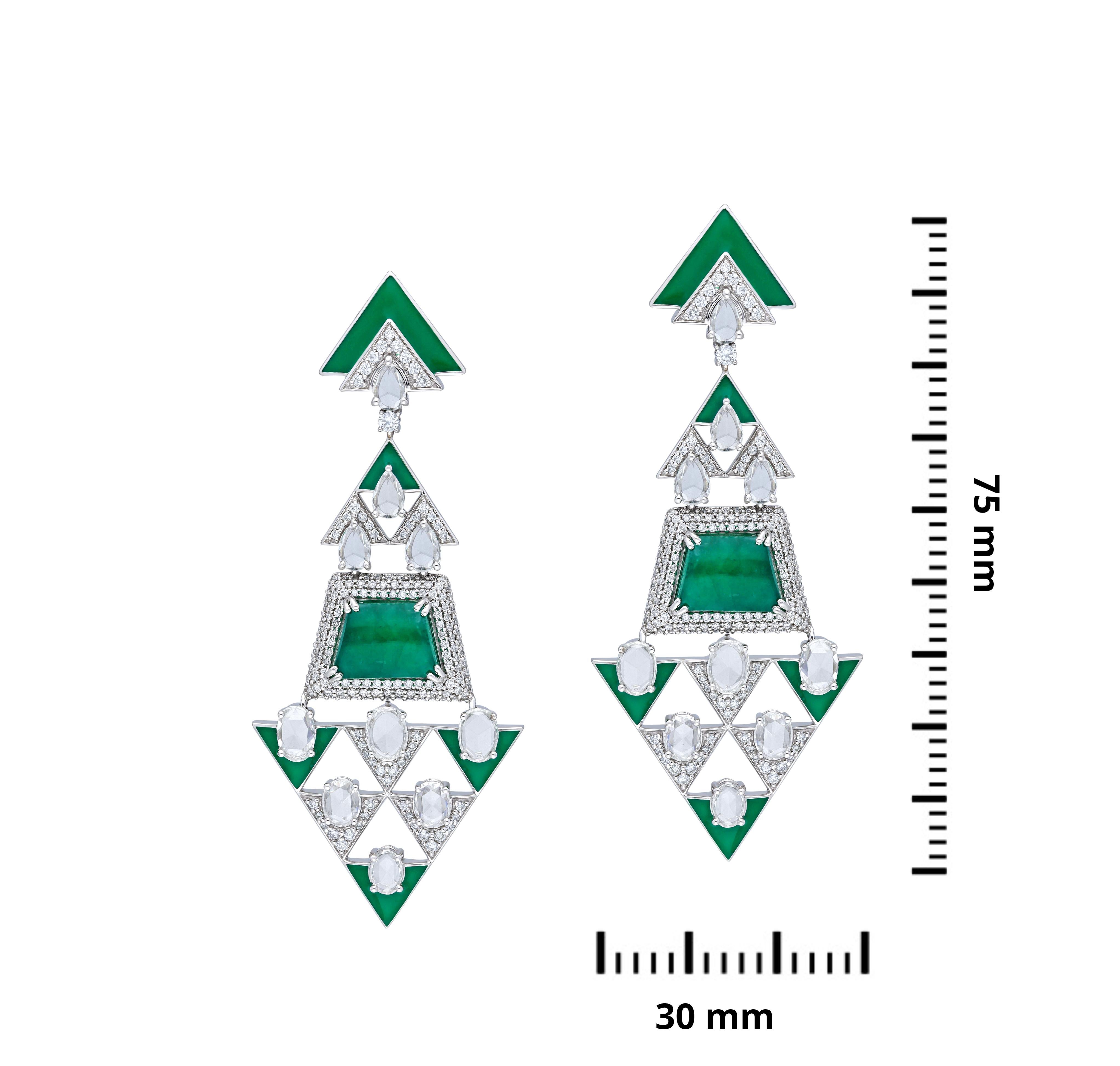 A pair of long earrings in couture cut emerald cabochons with rose & full cut white diamonds.  Mirroring a geometric façade in a triangular pattern of oval rose cut diamonds with emerald cabochons & triangular edges of green enamel, all mounted on a