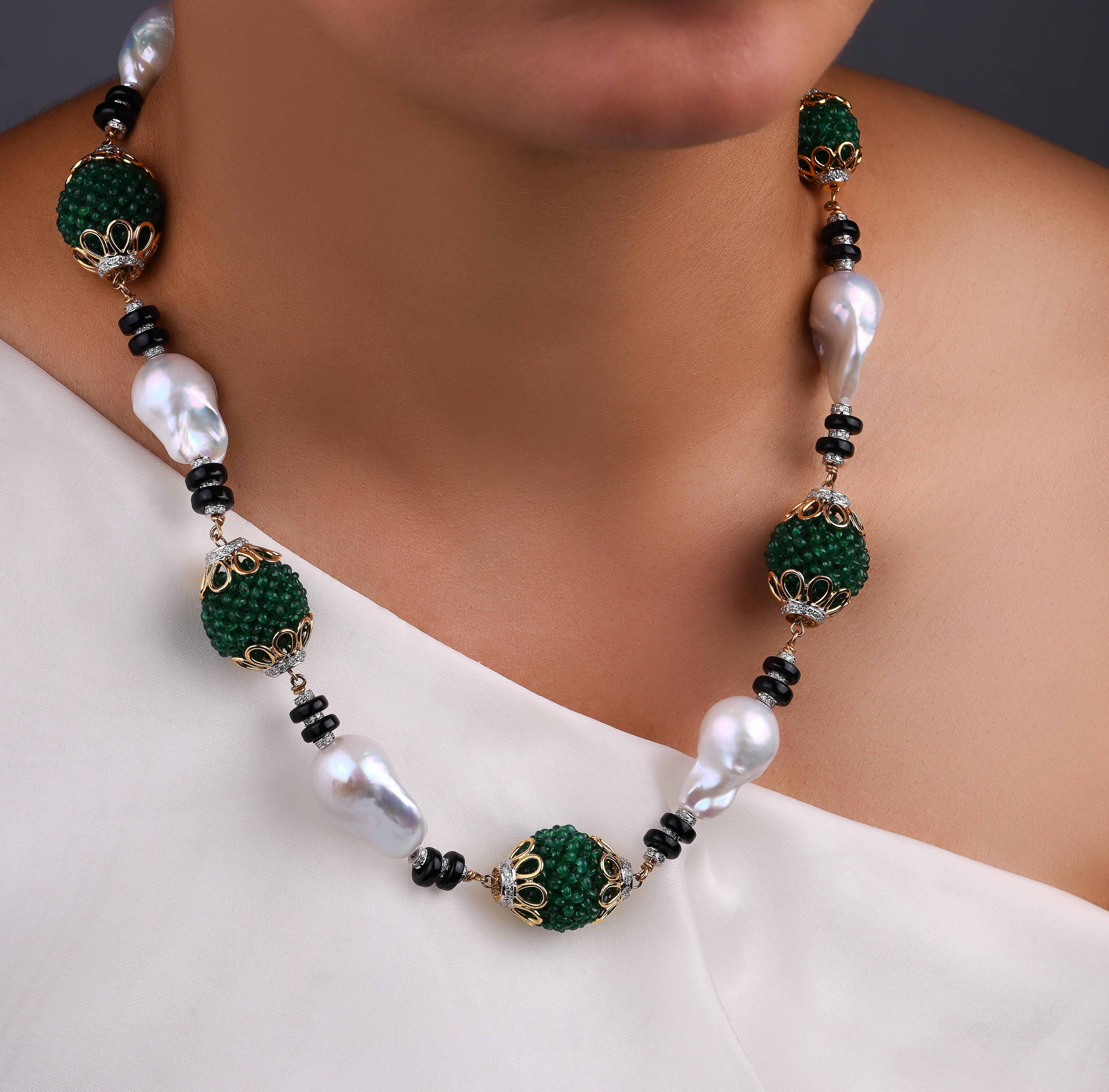 An Avant-garde pearl necklace. Strung with baroque ivory pearls with black onyx & diamond discs, alternating with balls made of Zambian emerald beads. Perfect for the opera or just brunch. The ball of emerald beads is strung together by complete