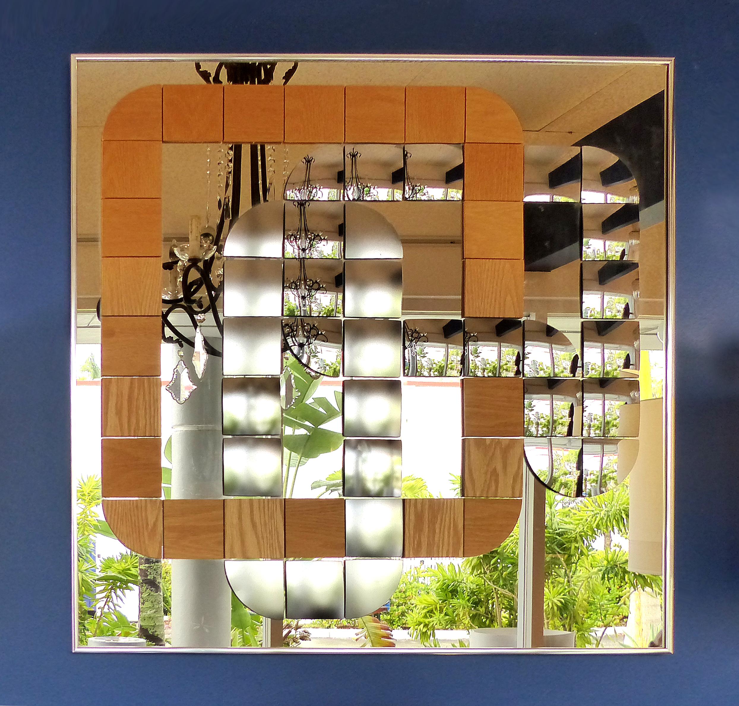 Offered for sale is a Hal Bienenfeld geometric optical art wood and mirror decorative wall composition. The mirror incorporates curves and movement with the use of different finished and shaped mirrored panels contrasting with wood panels. The