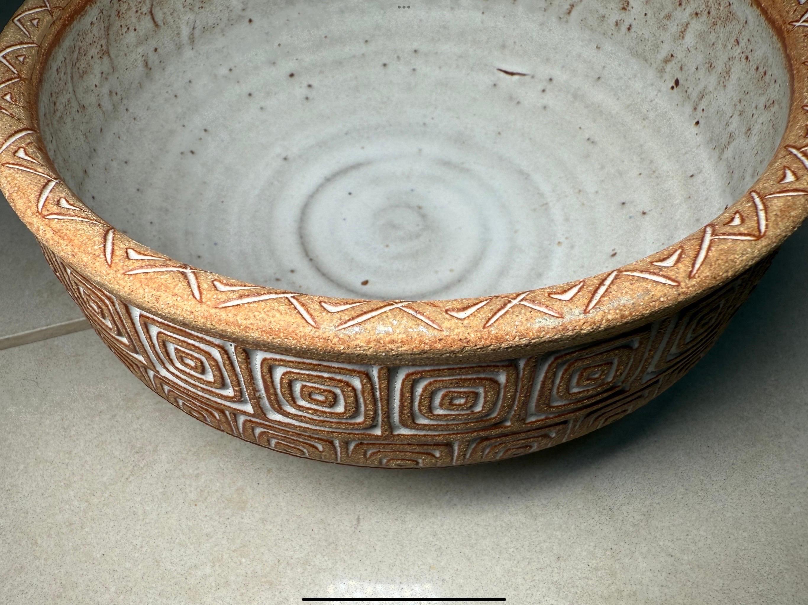 Si tratta di un piatto di terracotta artigianale portoricano, una ciotola per frutta e verdura. Raffigura una ciotola rotonda e pesante di colore bianco, decorata con una tecnica artistica a graffito con due file di piccoli e grandi quadrati color