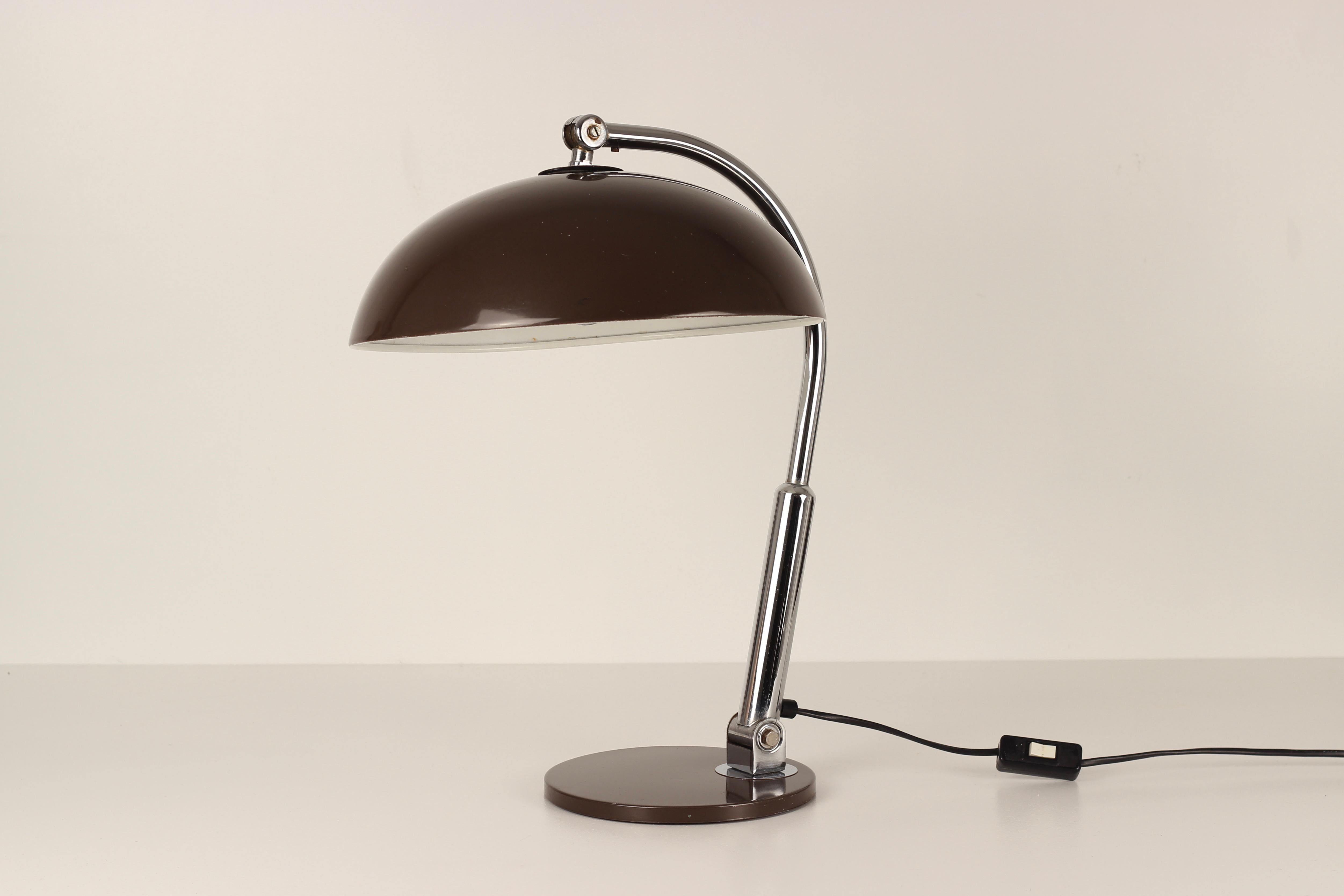 Lampe populaire conçue par Busquet et fabriquée par Hala Zeist Lampenfabriek aux Pays-Bas, vers les années 1960. Cette pièce est dotée d'un abat-jour en forme de dôme brun foncé et d'une base en forme de disque plat. Il peut être ajusté et