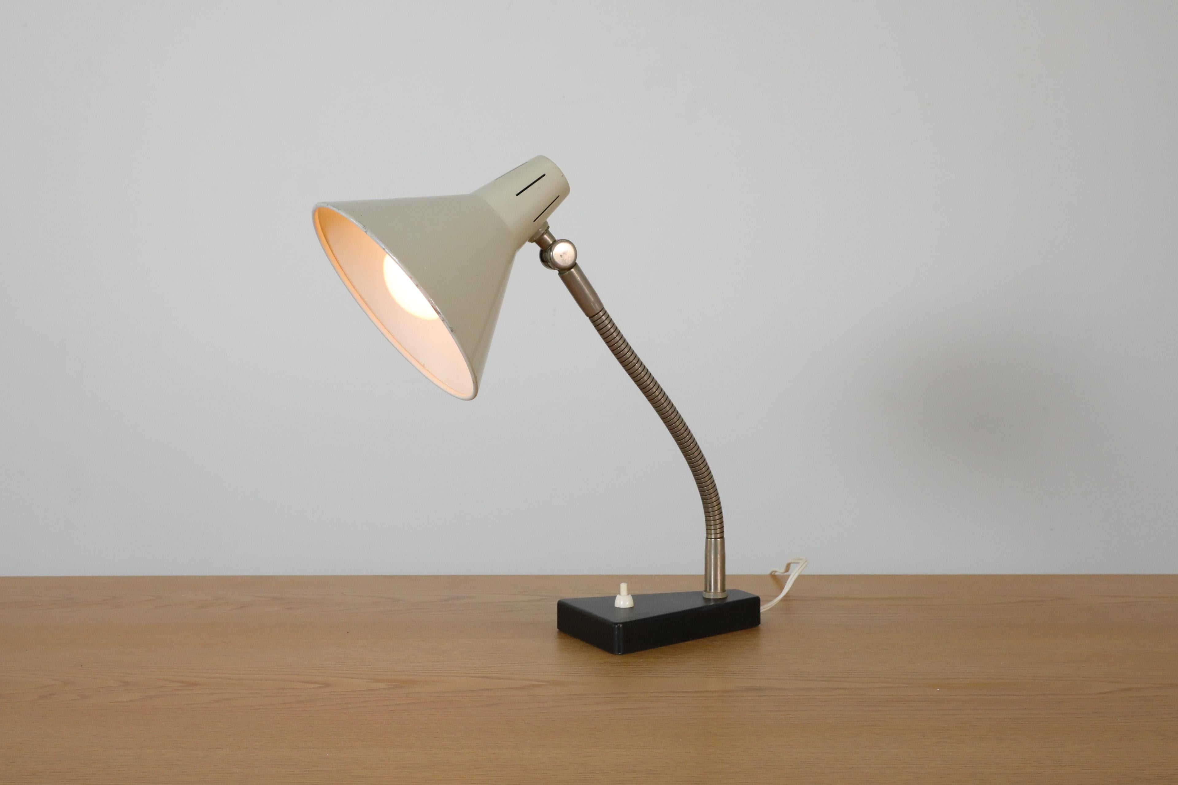 Dutch, Mid-Century, Hala Zeist manufactured table lamp with an adjustable gray enameled shade and a chrome gooseneck stem on top of a black base. A cute table lamp perfect for adding a touch of style and ambient directional light to a desk or side