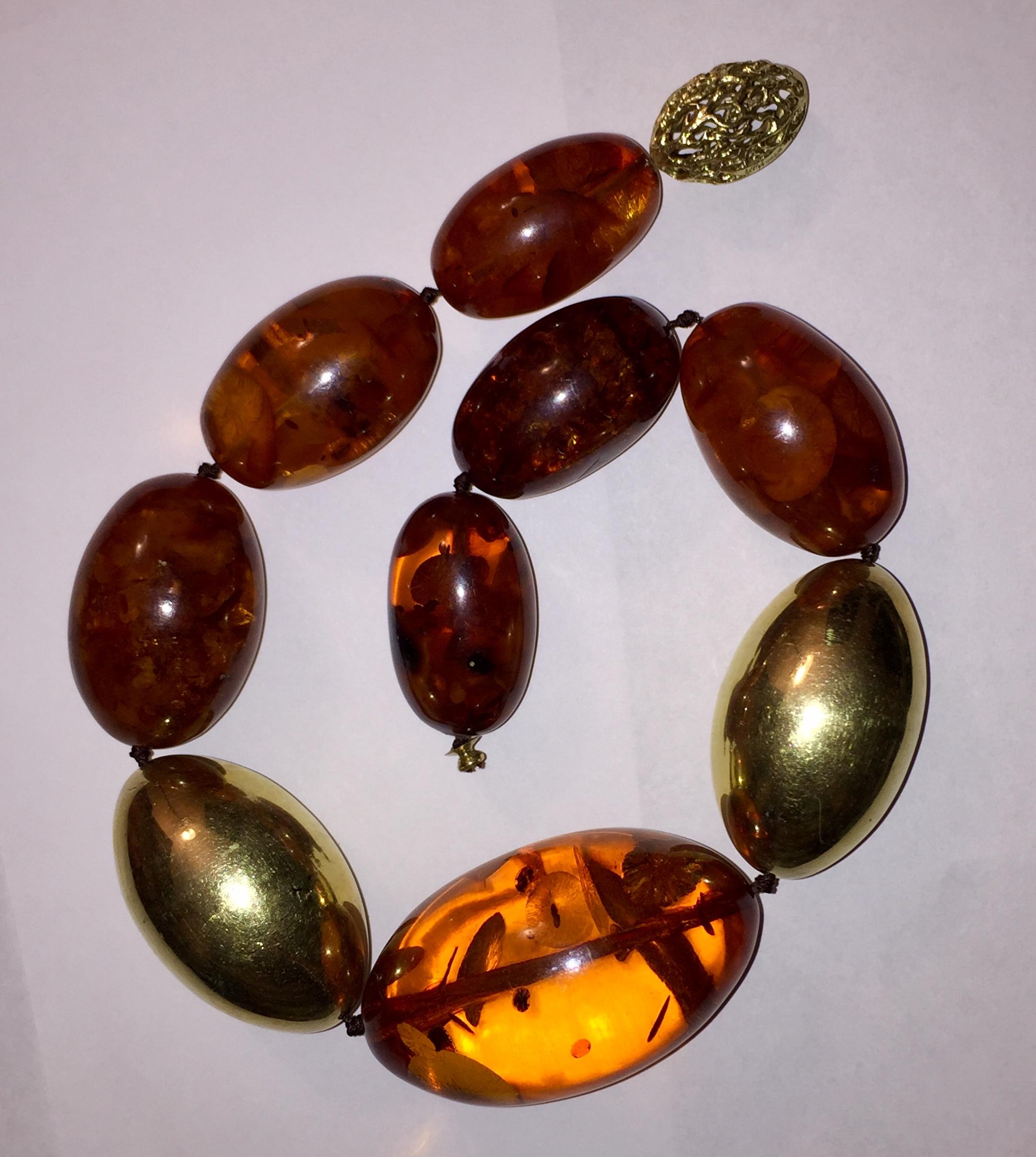 14 karat yellow gold knotted Orange Baltic Amber Oblong Bead Necklace. Measures 18.5” long and 1.5” wide. Hollow filigree oblong clasp marked, AH, 585, Willy Fagert. Weighs, 188.3 grams.