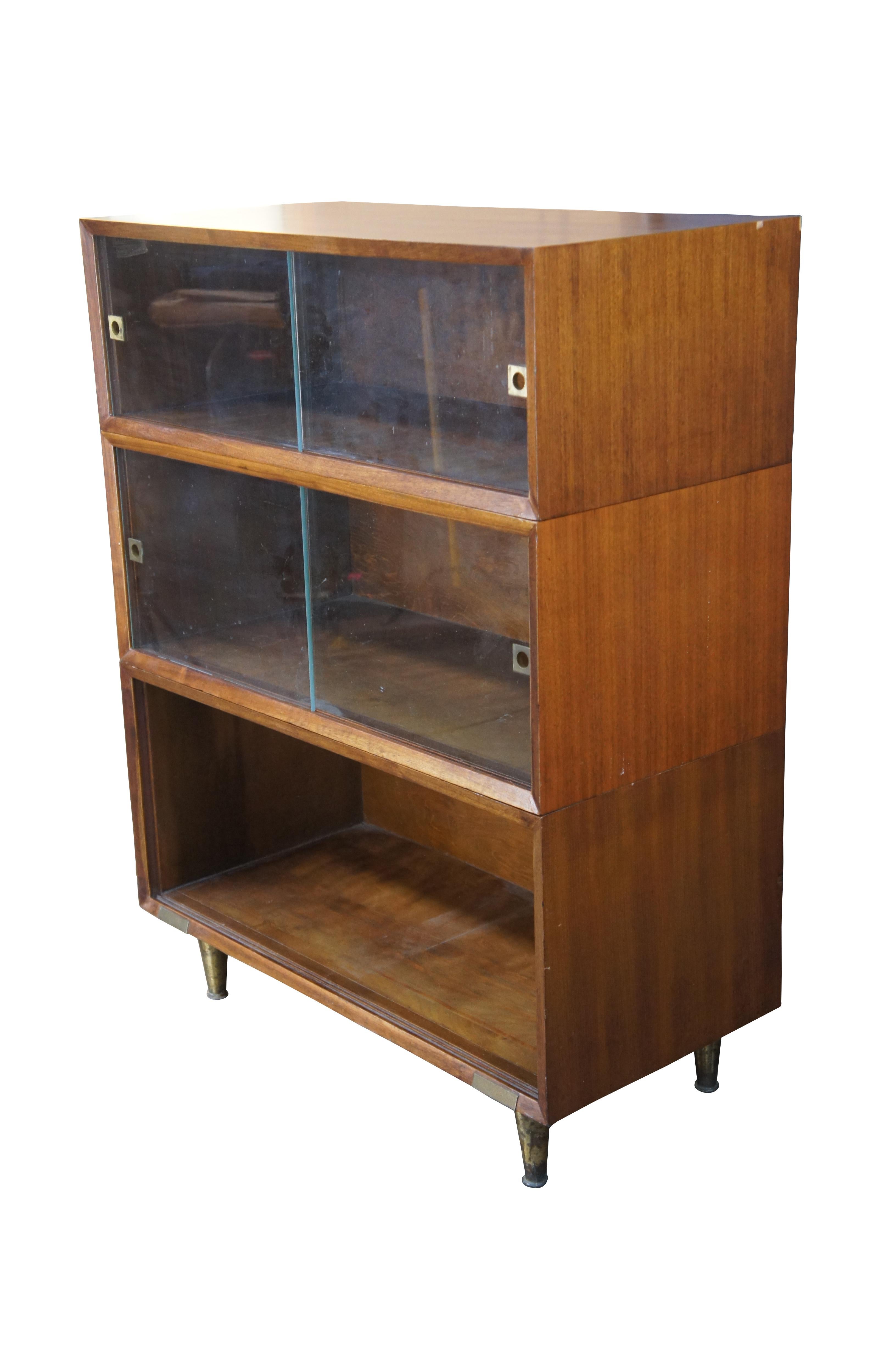 Hale Manufacturing Company Barrister Style Bookcase / Display Cabinet, circa 1970s. Made from gunstock walnut with brass tapered legs. The top two shelves have sliding glass with brass handles. The bottom section is missing glass. an intriguing