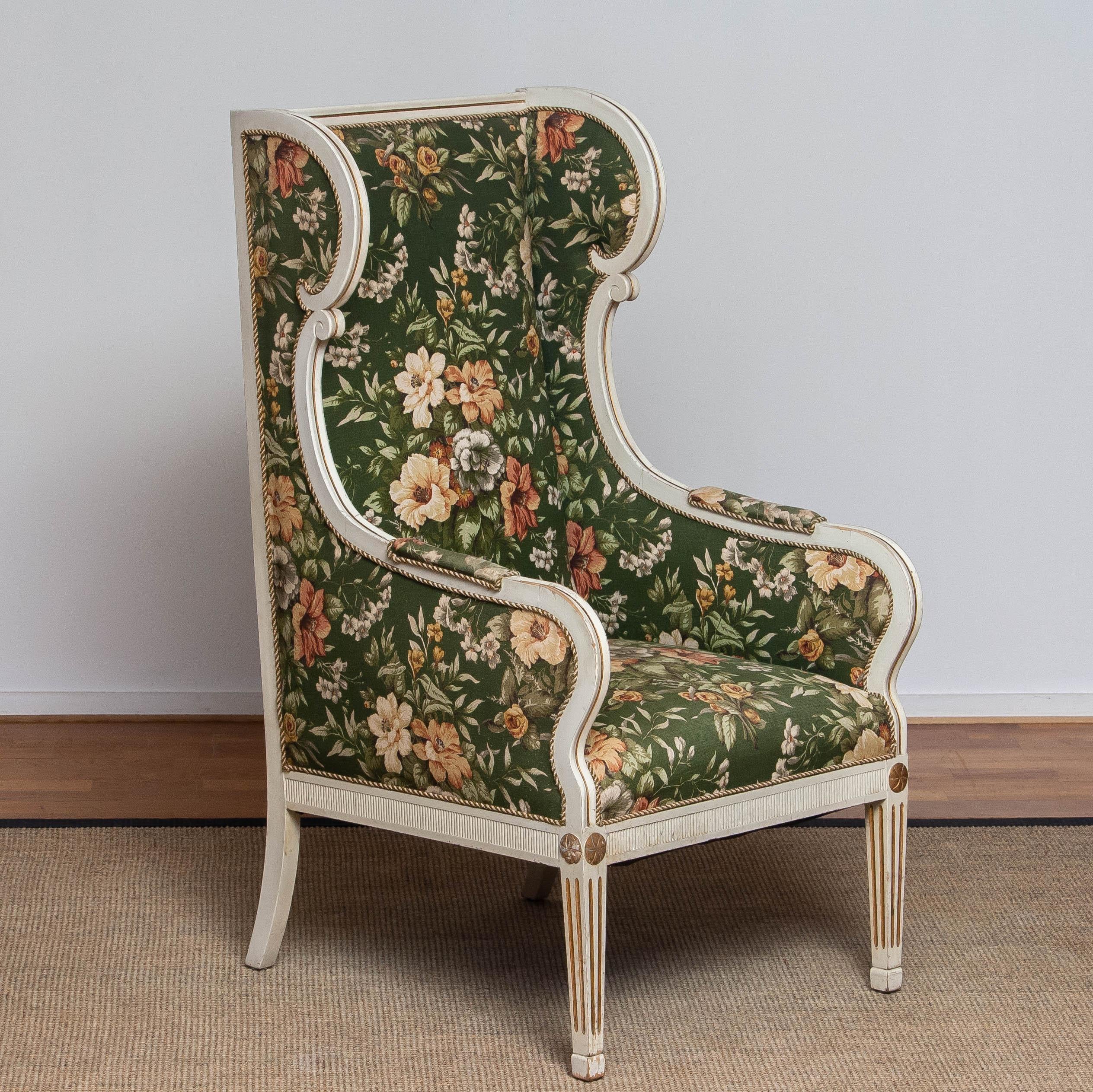 Very rare and beautiful half 19th century white, with golden accents, Gustavian / Swedish model wingback lounge chair made by One Christian Petersen in Copenhagen. This tall chair is upholstered with a beautiful, printed, flower motive on linnen