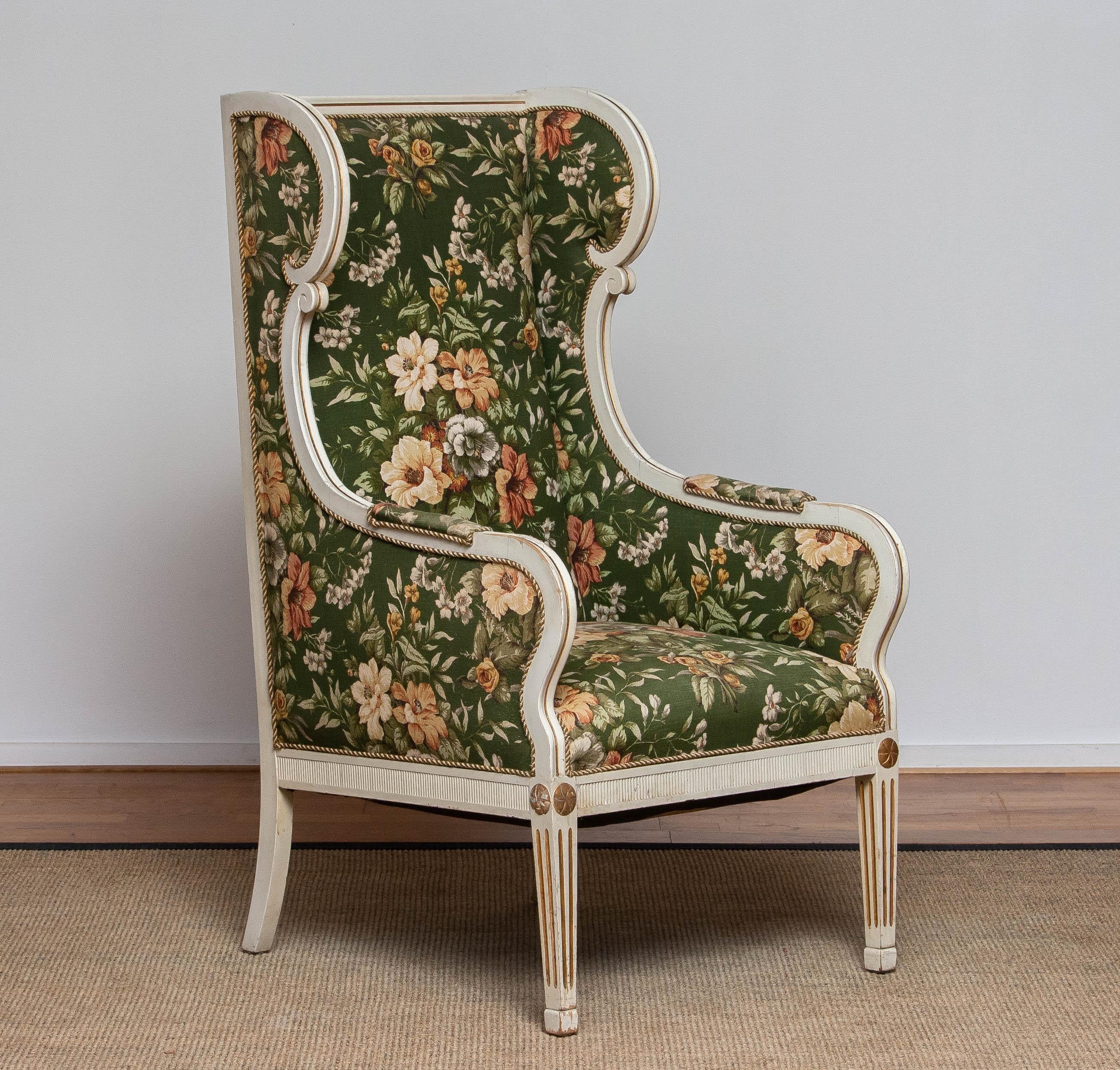 Very rare and beautiful half 19th century white, with golden accents, Gustavian / Swedish model wingback lounge chair made by One Christian Petersen in Copenhagen. This tall chair is upholstered with a beautiful, printed, flower motive on linnen