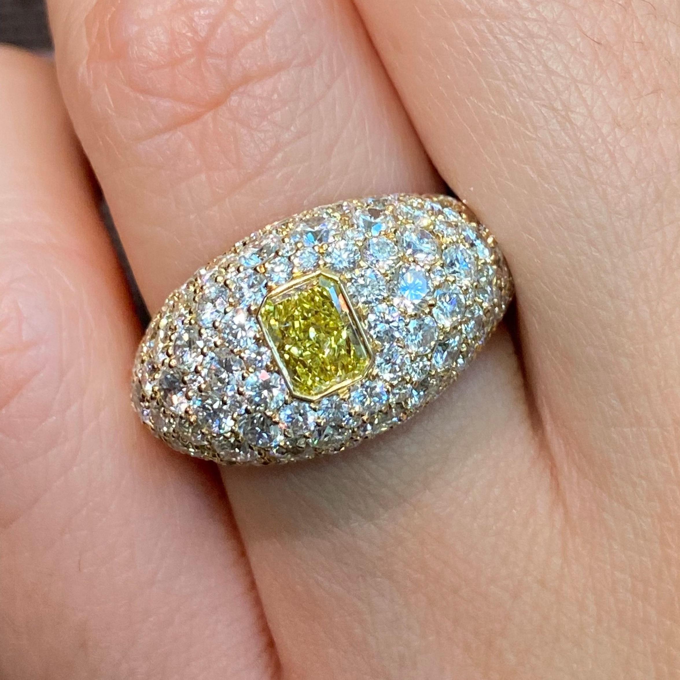 Scopri la bellezza di questo anello da mezzo carato Fancy Yellow Intense Radiant con cupola di diamanti. Con un diamante centrale allungato a taglio radiante da 0,52 carati, la sua vibrante tonalità gialla è splendidamente completata da 4,29 carati