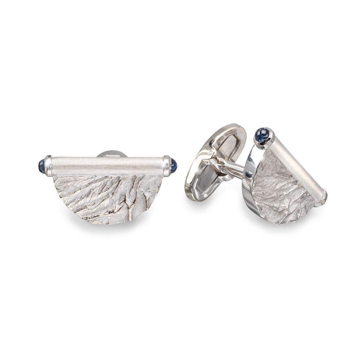 These 18k white gold cufflinks, adorned with blue sapphires, invoke the cool, crisp image of serene mountain landscapes on the reticulated half disc link. Dare to be bold and stand out from the crowd.

