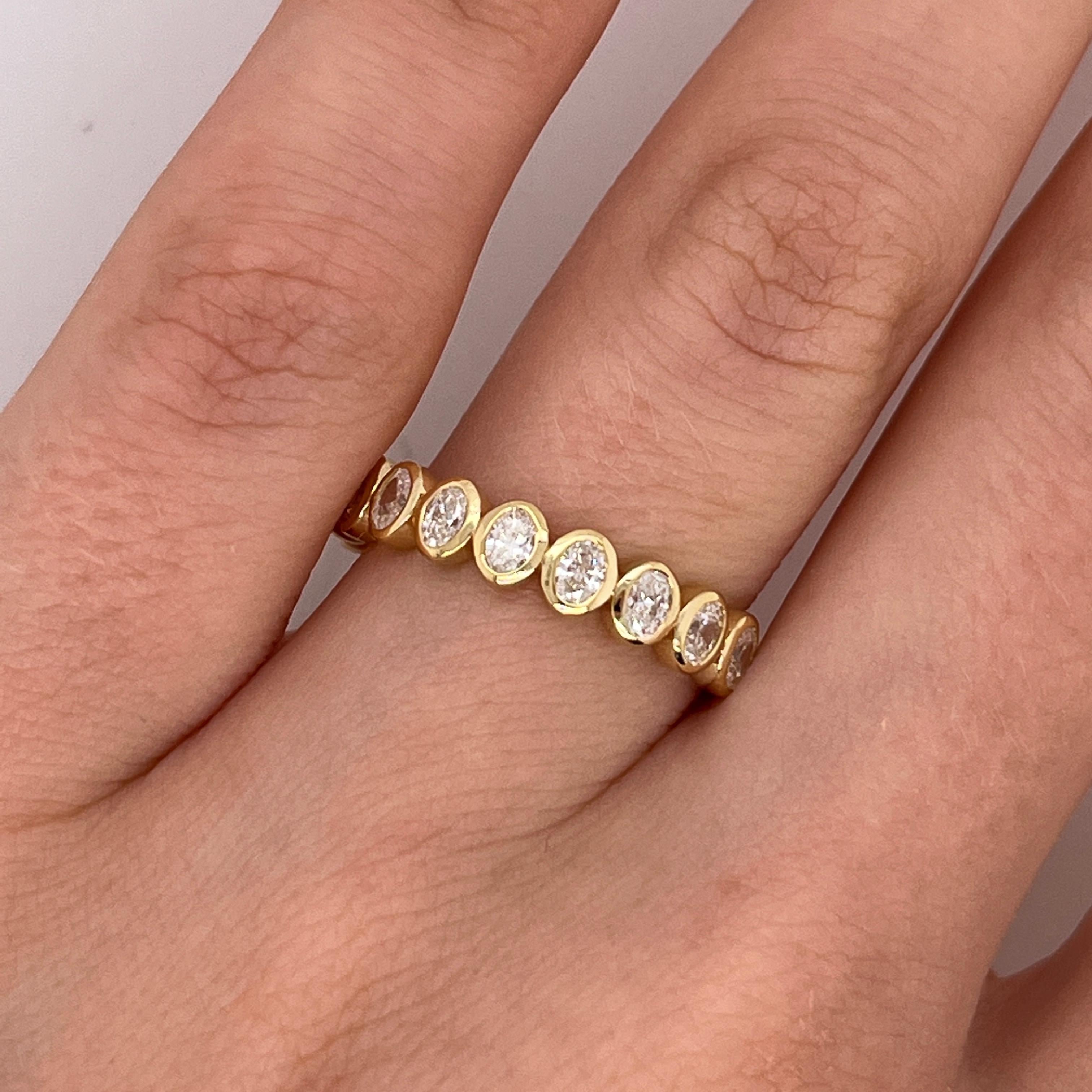 This elegant half eternity ring is set with a row of natural oval-cut diamonds, totaling 0.85ct, finely mounted in a band of 18ct yellow gold. 
The classic silhouette combined with the soft curves of oval diamonds creates a timeless and graceful
