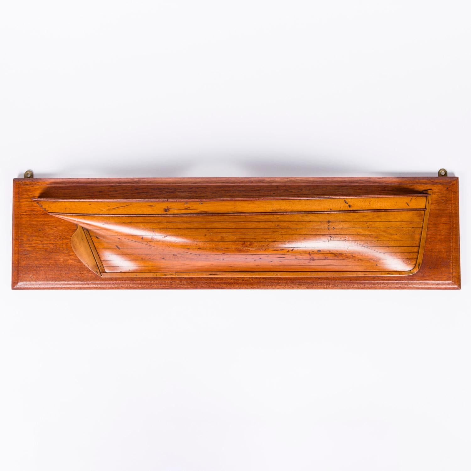 A late 19th century half block model of the starboard side of a Barque, circa 1880.  

The hull is made from laminated sections.

The teak backboard has brass hanging eyes.

