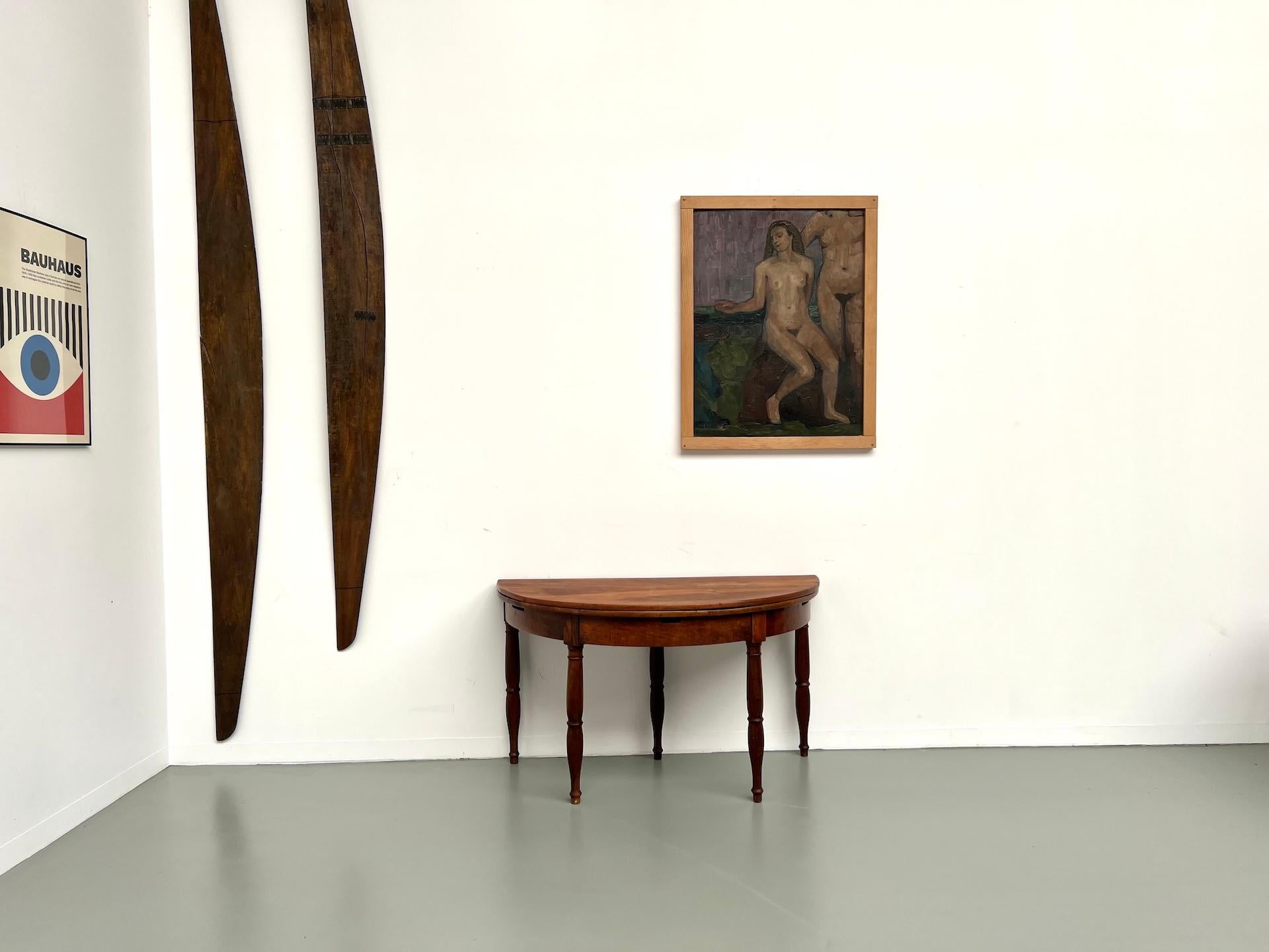 Half-moon walnut table, circa 1900 — entirely original.
A console one moment, an intimate dining table the next: with a single gesture the hinged top unfurls into a full circle ready for four guests.

The walnut, seasoned by more than a century of