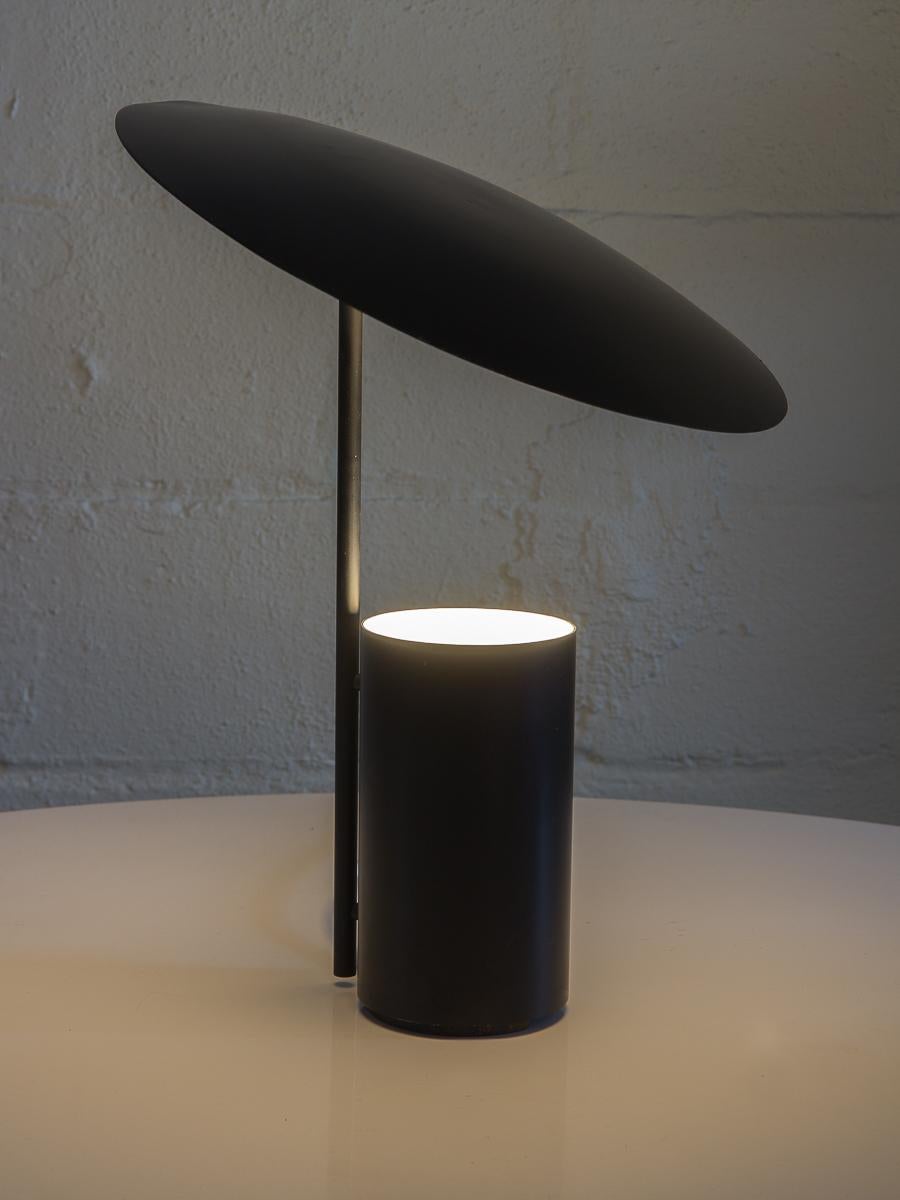 Hardly seen, black Half Nelson table lamp produced by Koch and Lowy from 1977. An Minimalist, geometric modern table sculpture. Lightbulb sits in a cylindrical base design shielded by the tilted dome shade. Adjust to change the lighting. Lamp has