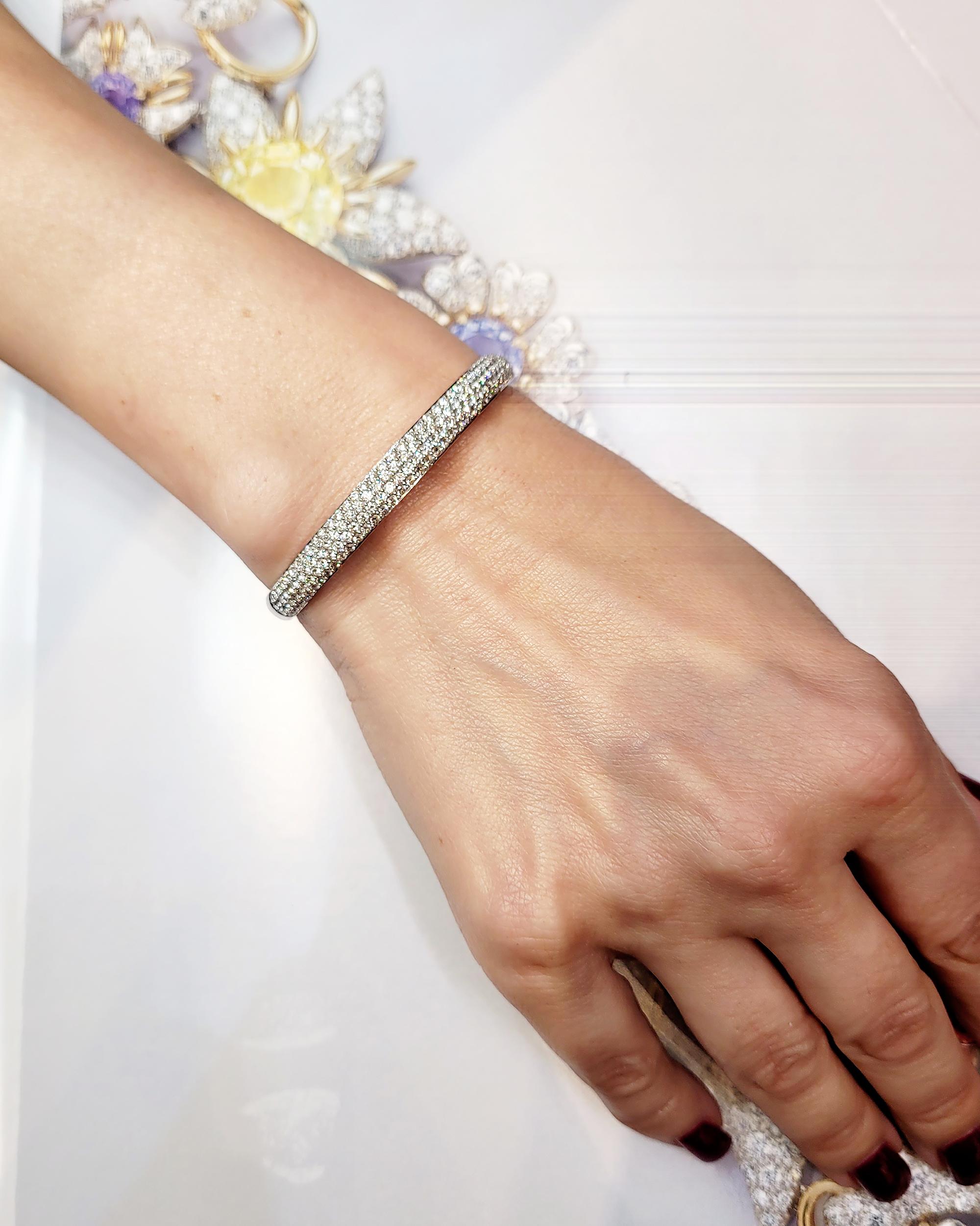 A timeless symbol of elegance and refinement, this exquisite half pavé diamond bracelet is beautifully crafted in 18k white gold. The sleek, polished gold band is adorned with 155 round brilliant-cut diamonds, totaling approximately 3.10 carats,