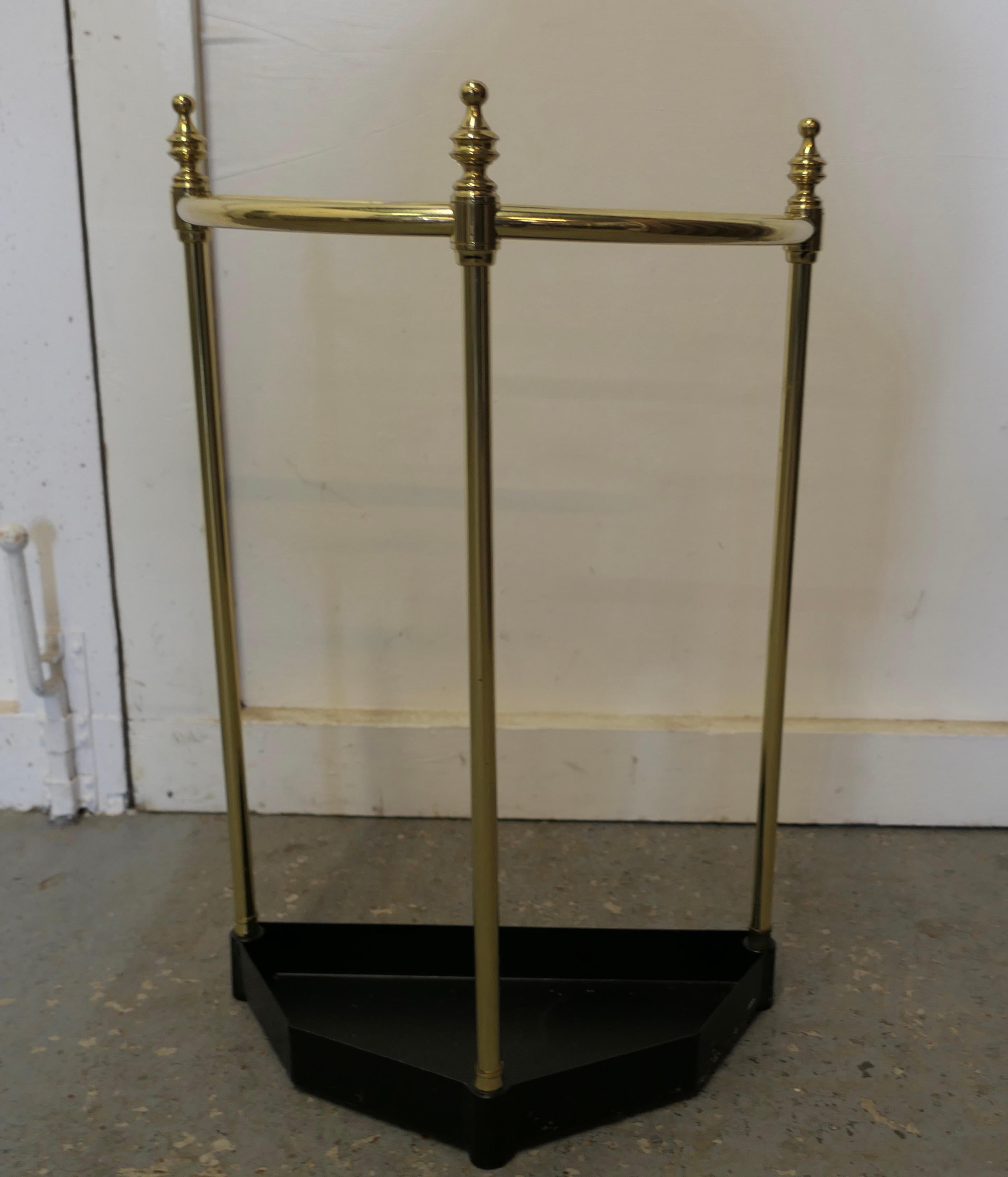Half round brass & iron stick stand or umbrella stand

A charming piece, and it has a very unusual half moon shape, the stand is divided into 5 sections to hold either walking sticks or umbrellas and topped of with brass knobs, the heavy iron base