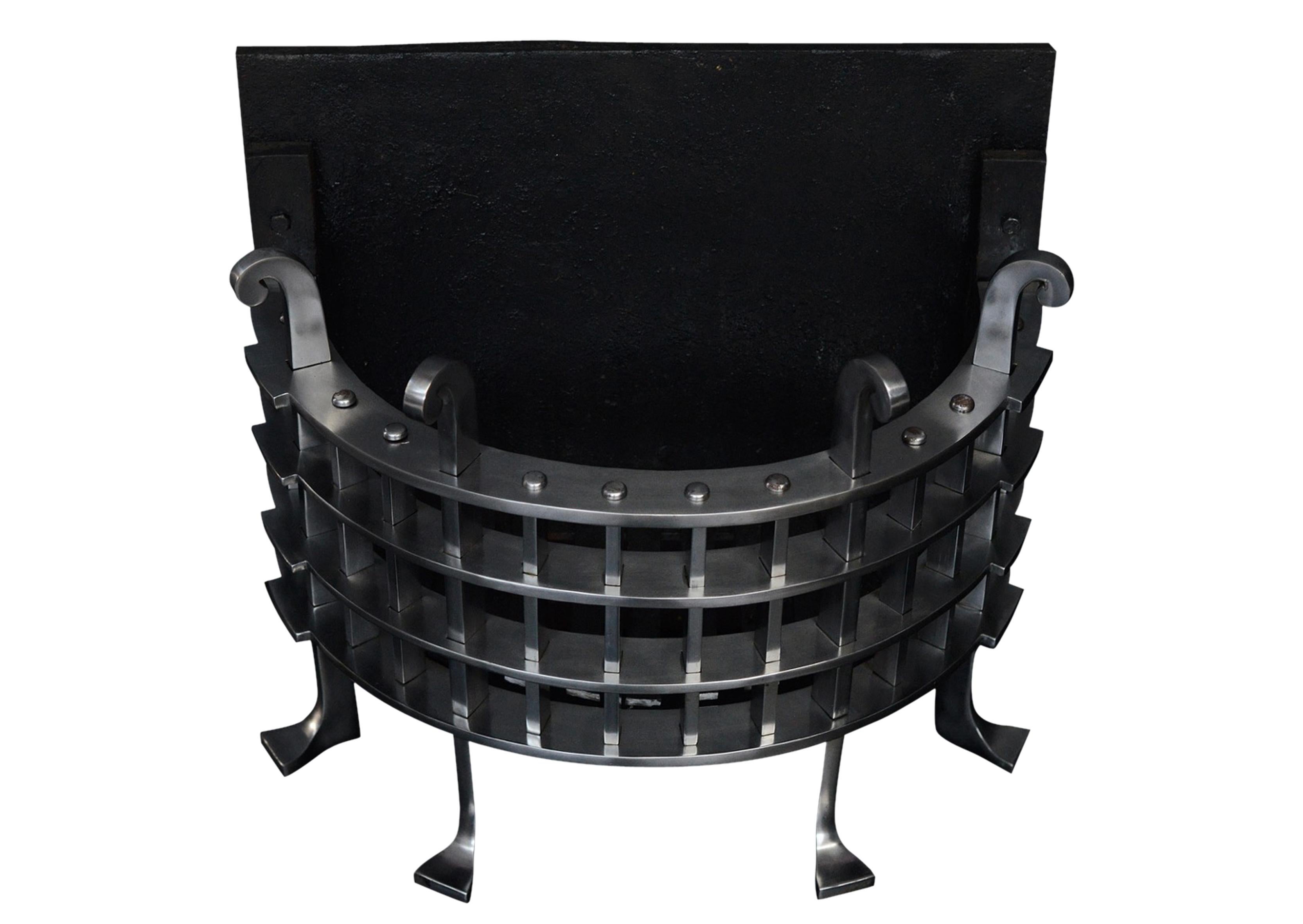 An unusual English half round wrought iron fire grate with portcullis style grill, upright bars with feet and scrolls to top. A copy of a mid-19th century original. N.B. May be subject to an extended lead time.

Width at front: 600 mm / 23 5/8